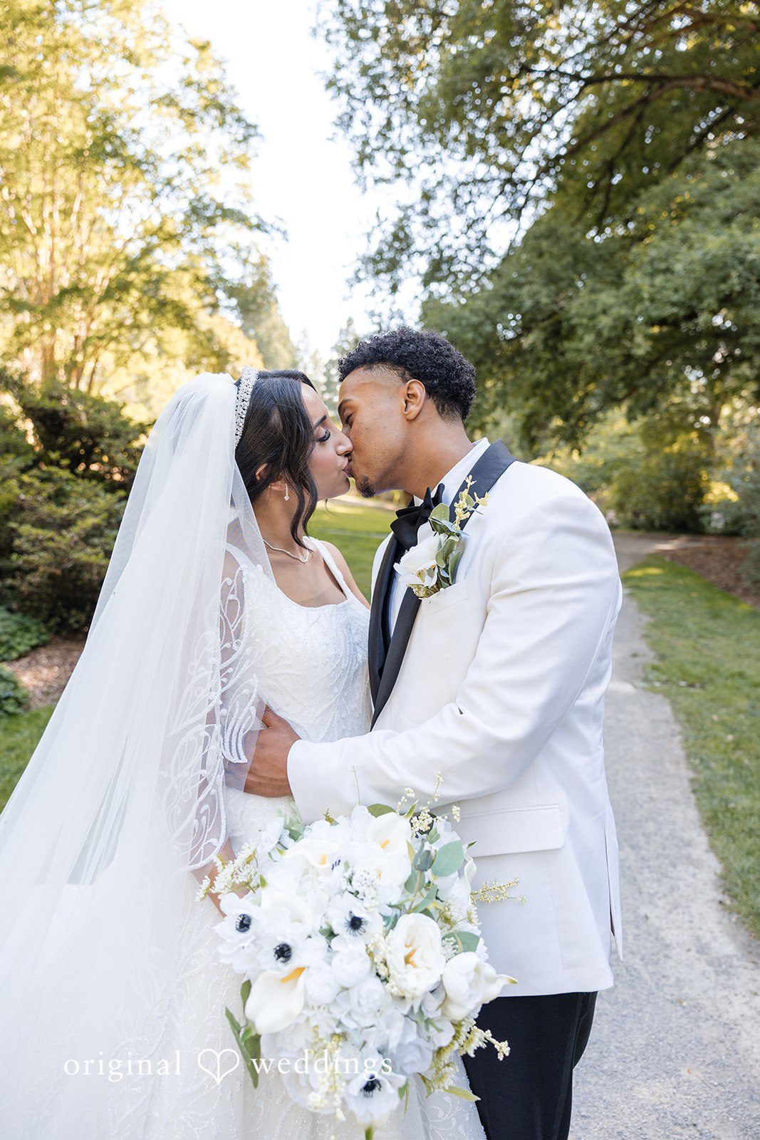 A groom kissing his bride at Aura Event Center.