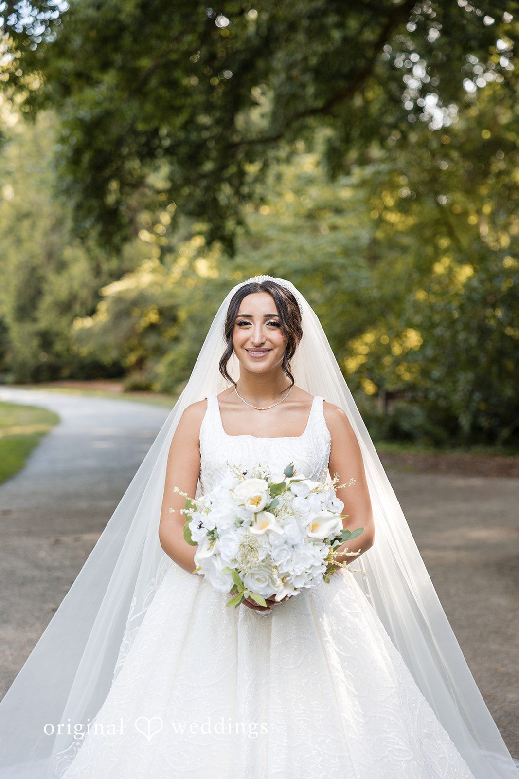 A bride in a large white ballgown holding a bouquet.