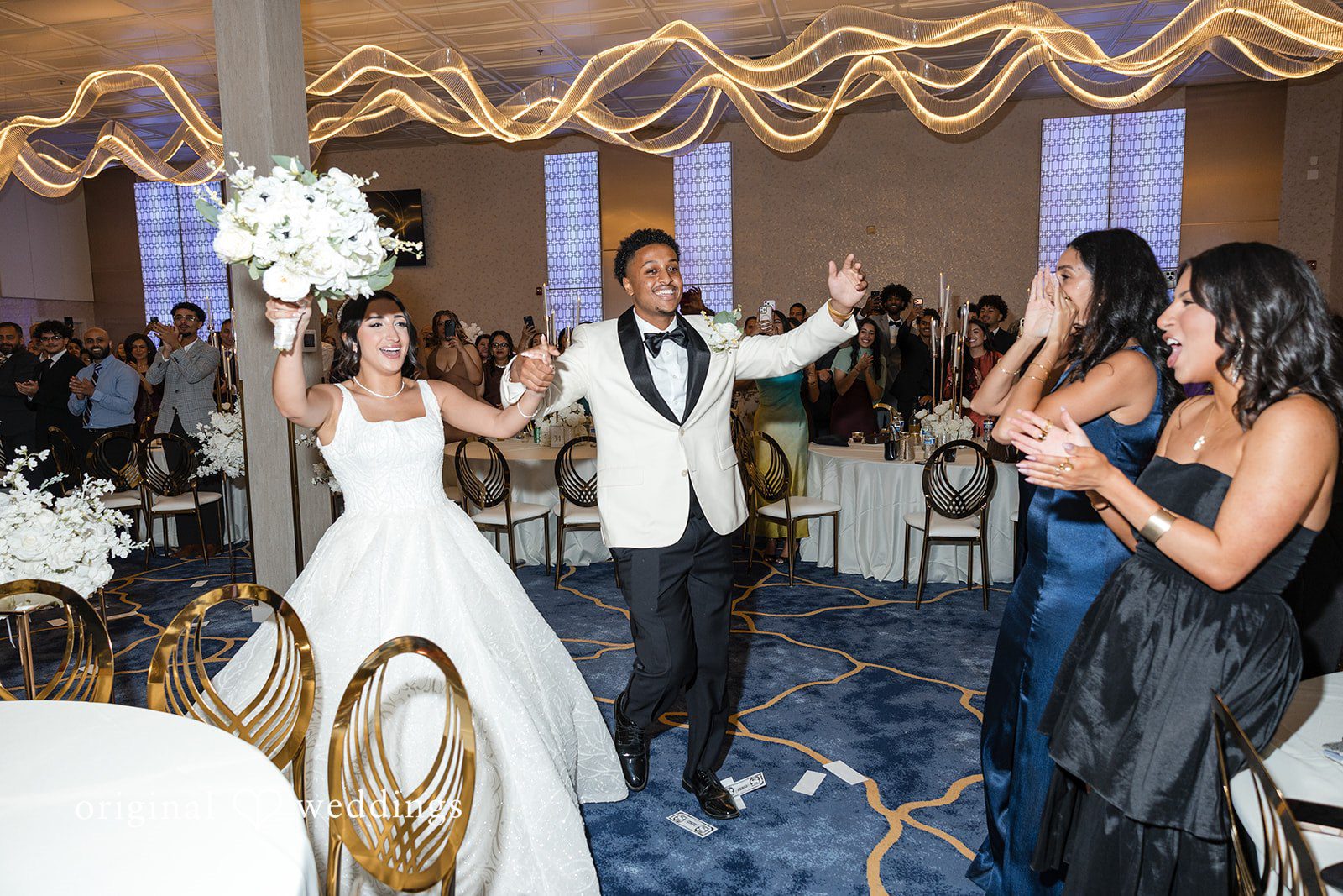 A bride and groom dancing energetically during their reception.