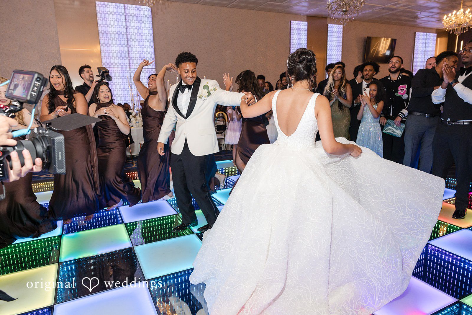A bride and groom dancing together on an illuminated LED dance floor.
