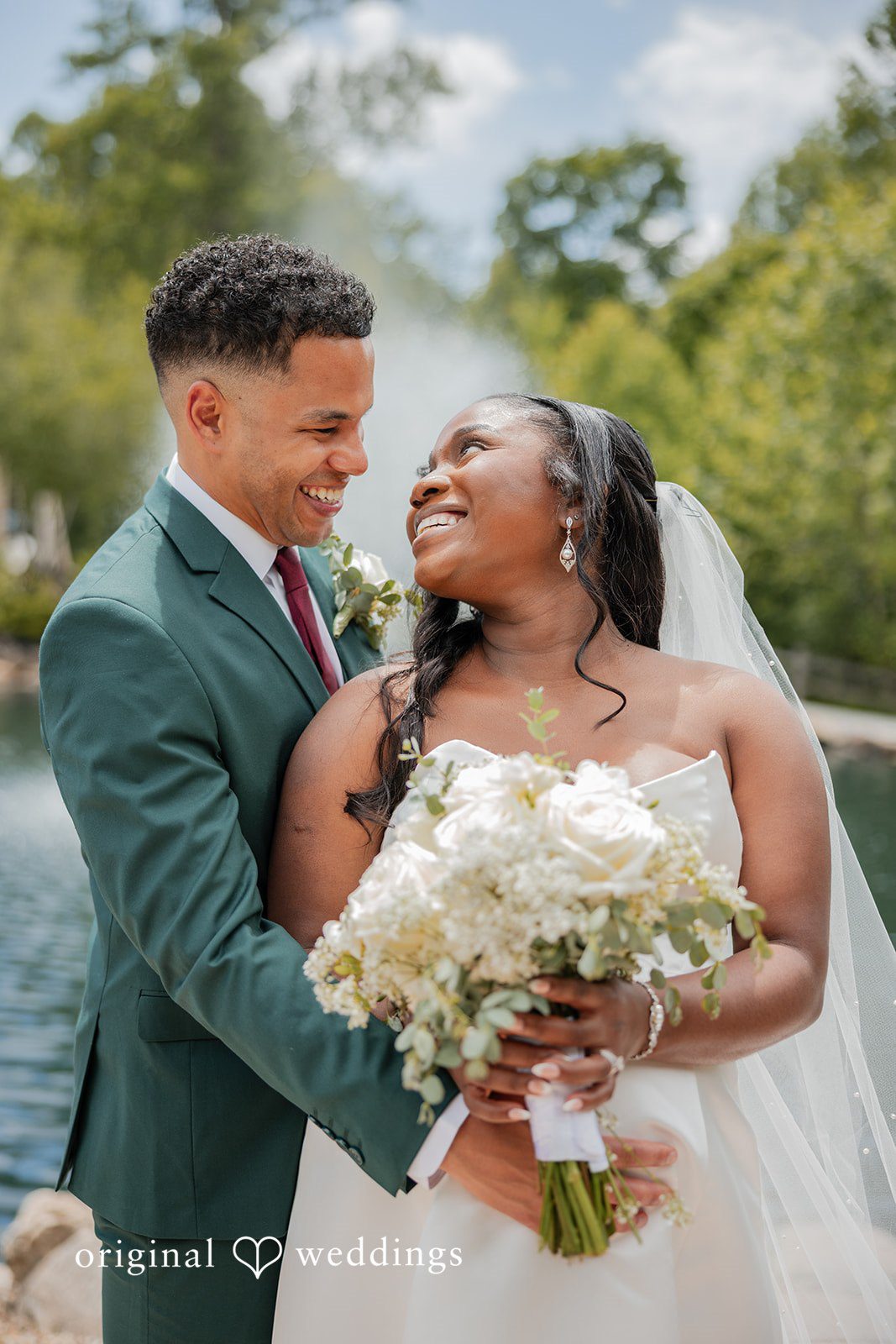Christopher + Maxine Bride and groom smiling widely while leaning close together.