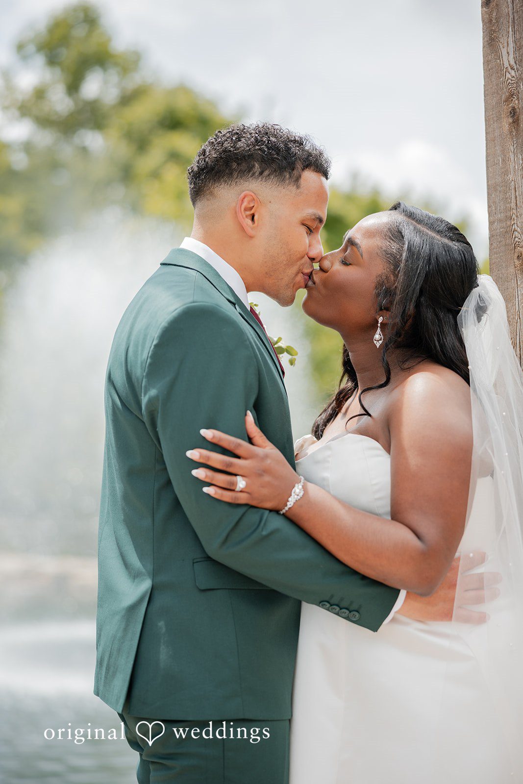 Christopher + Maxine Side profile view of a bride and groom leaning in close to each other.