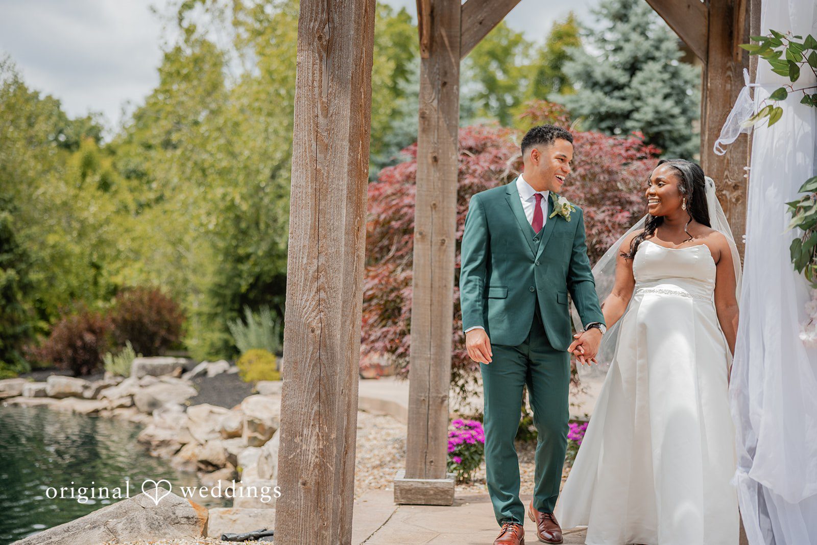 Christopher + Maxine Wedding procession walking down a paved path lined with stone architectural structures.