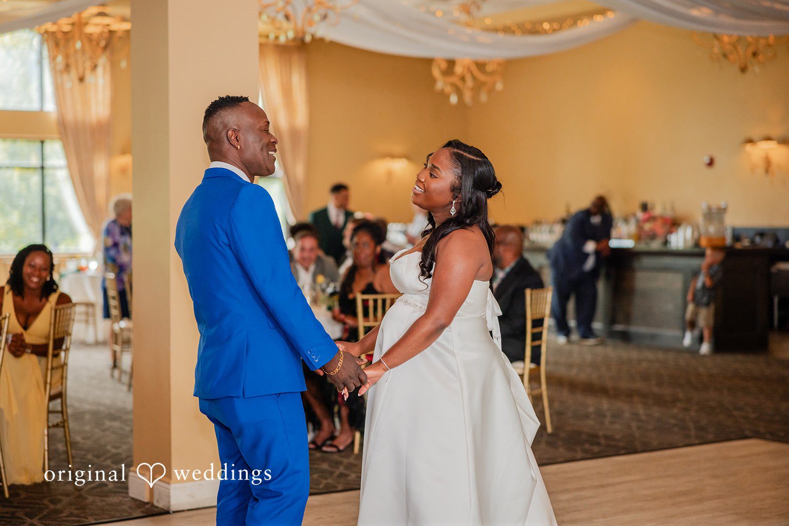 Christopher + Maxine Bride dancing with a man wearing a vibrant blue suit on the dance floor.
