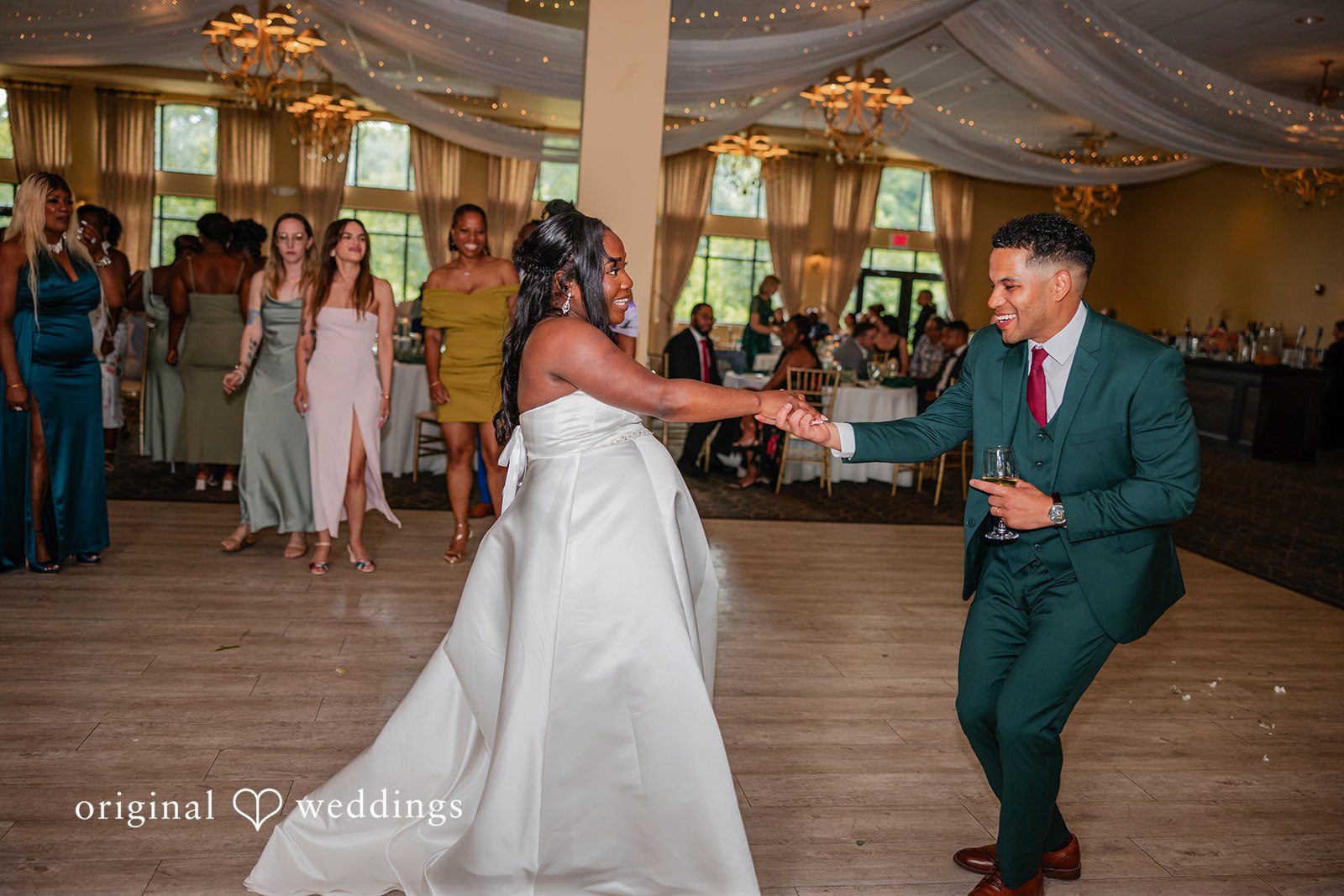 Christopher + Maxine Bride and groom dancing together on a dance floor surrounded by wedding guests.