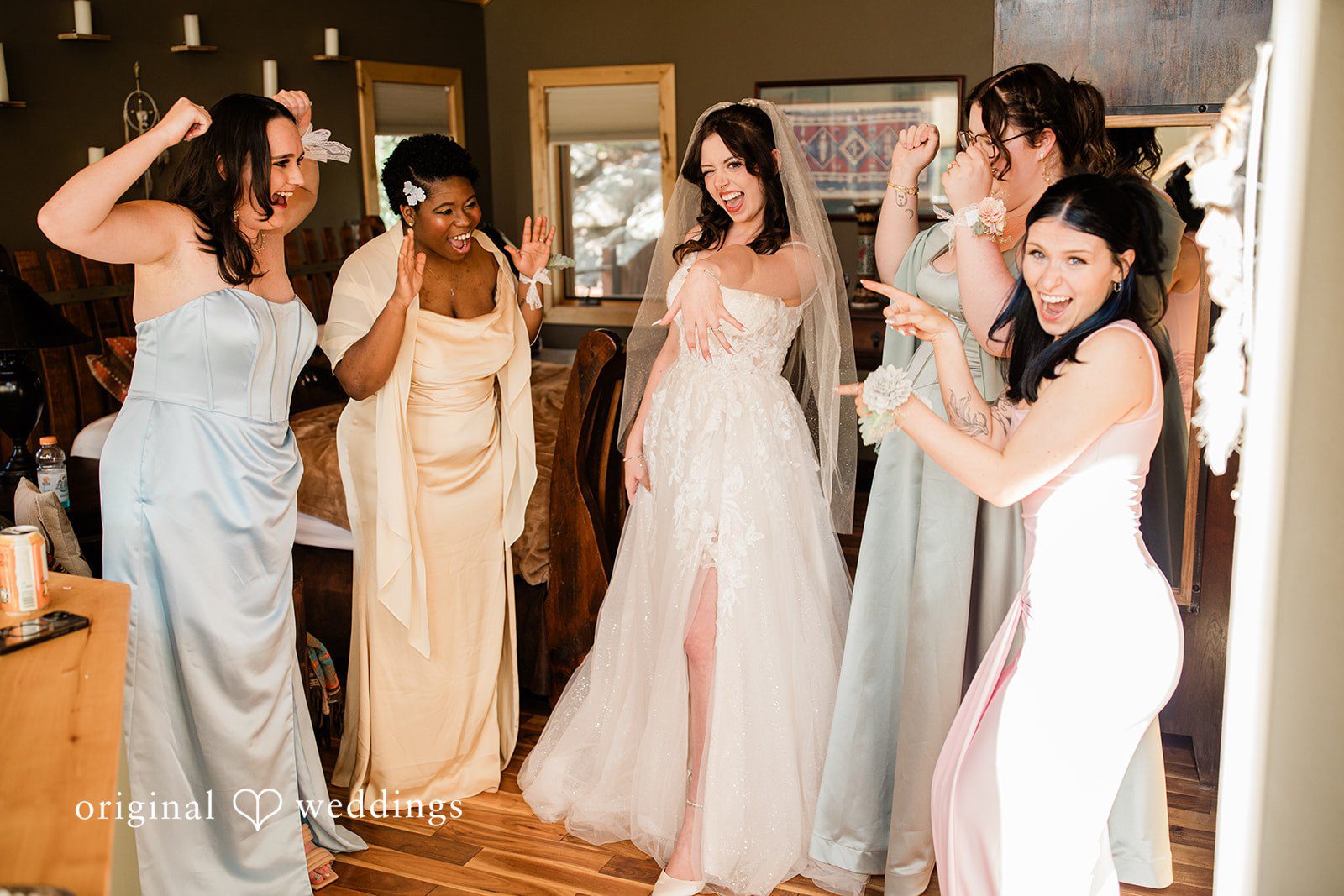 Madelyn + Erin A line of women standing together while dressed in long, light-colored gowns.
