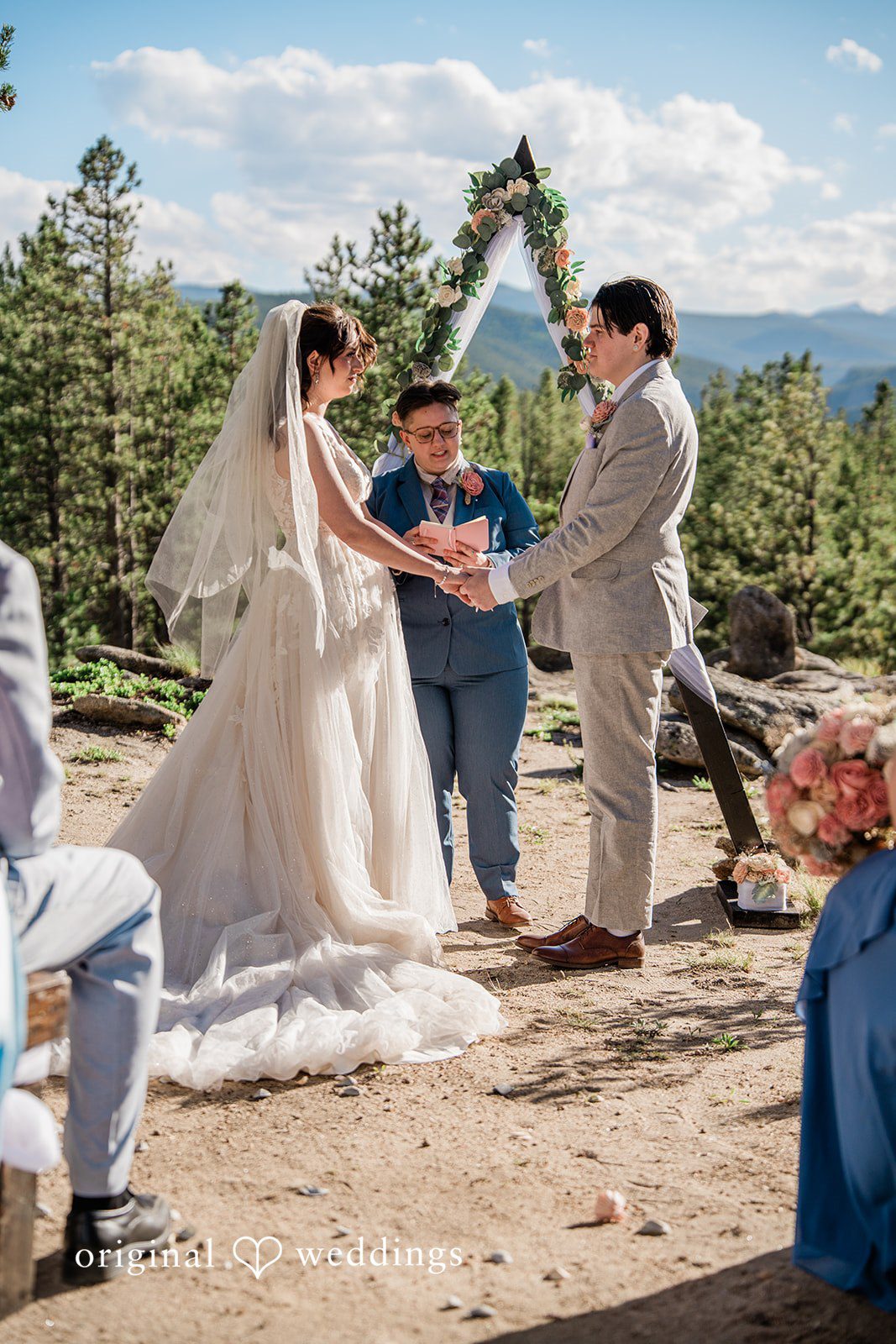 Madelyn + Erin A bride and groom standing at a mountain ceremony.