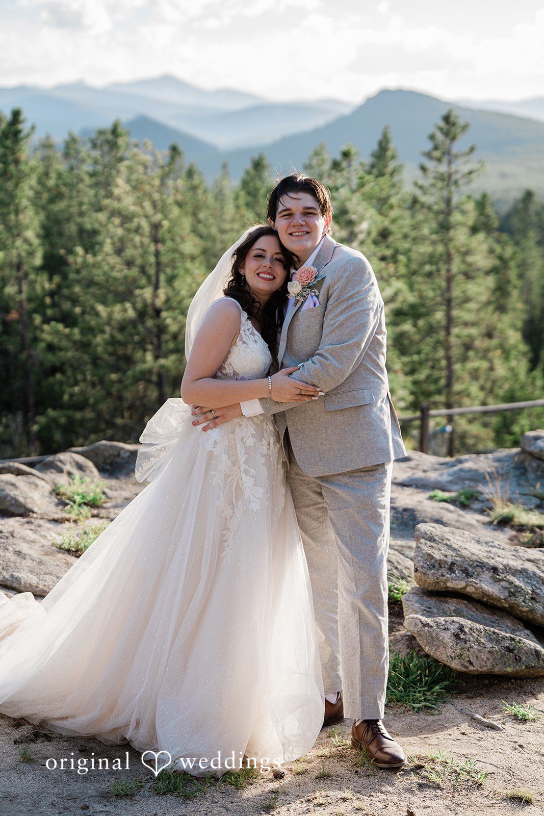 Madelyn + Erin A bride and groom hugging tightly on a scenic overlook.