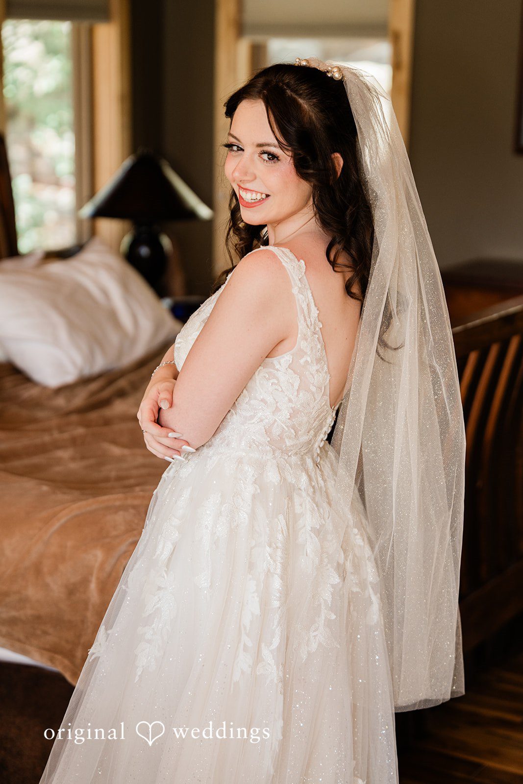 Madelyn + Erin A bride looking over her shoulder while wearing a white wedding gown and veil.