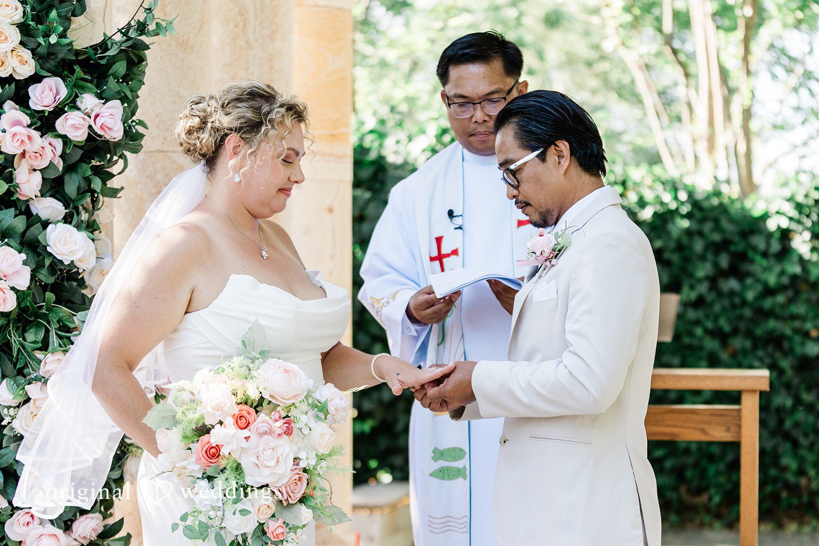 Lindsay + Ryan A bride and groom exchanging vows in front of an officiant during their ceremony.