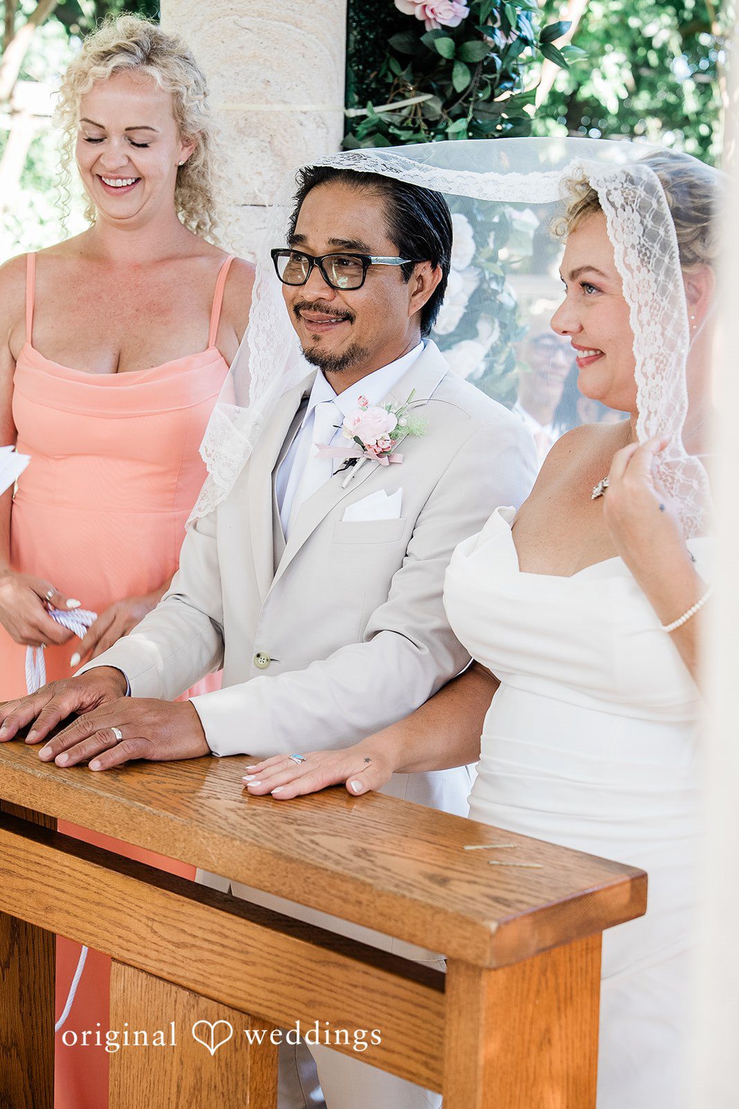 Lindsay + Ryan A bride and groom sitting together at a wooden altar table during a wedding service.