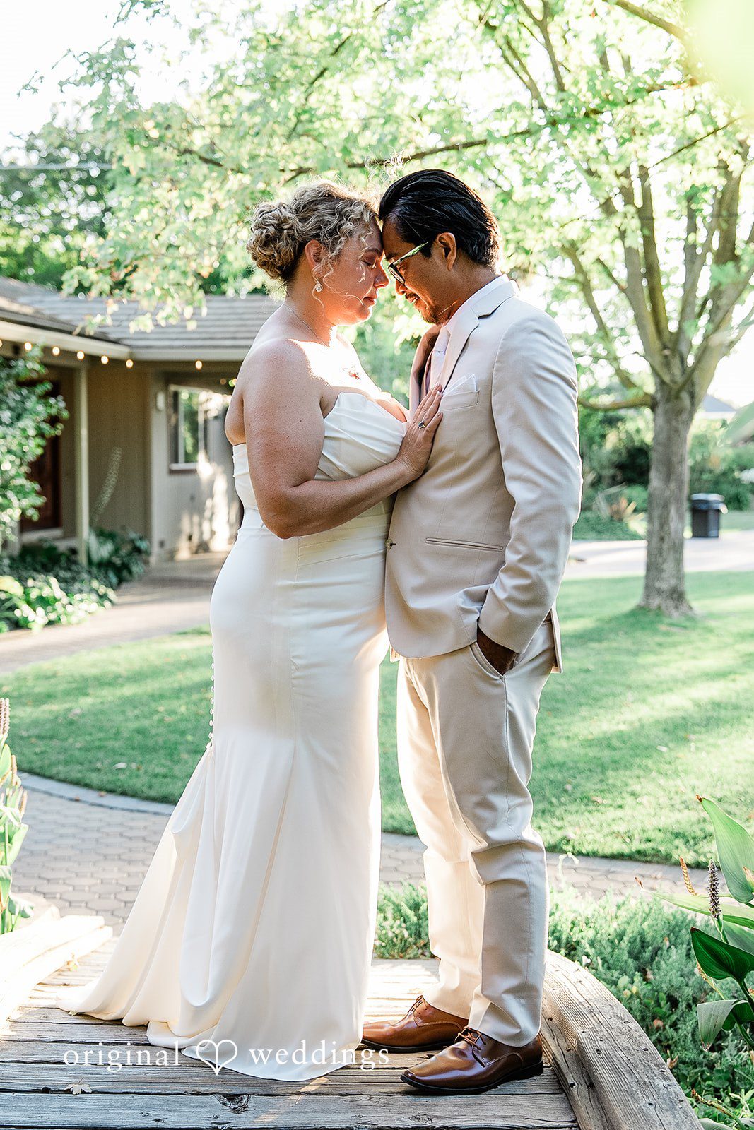 Lindsay + Ryan A bride and groom holding hands and sharing an intimate moment in a grassy area.