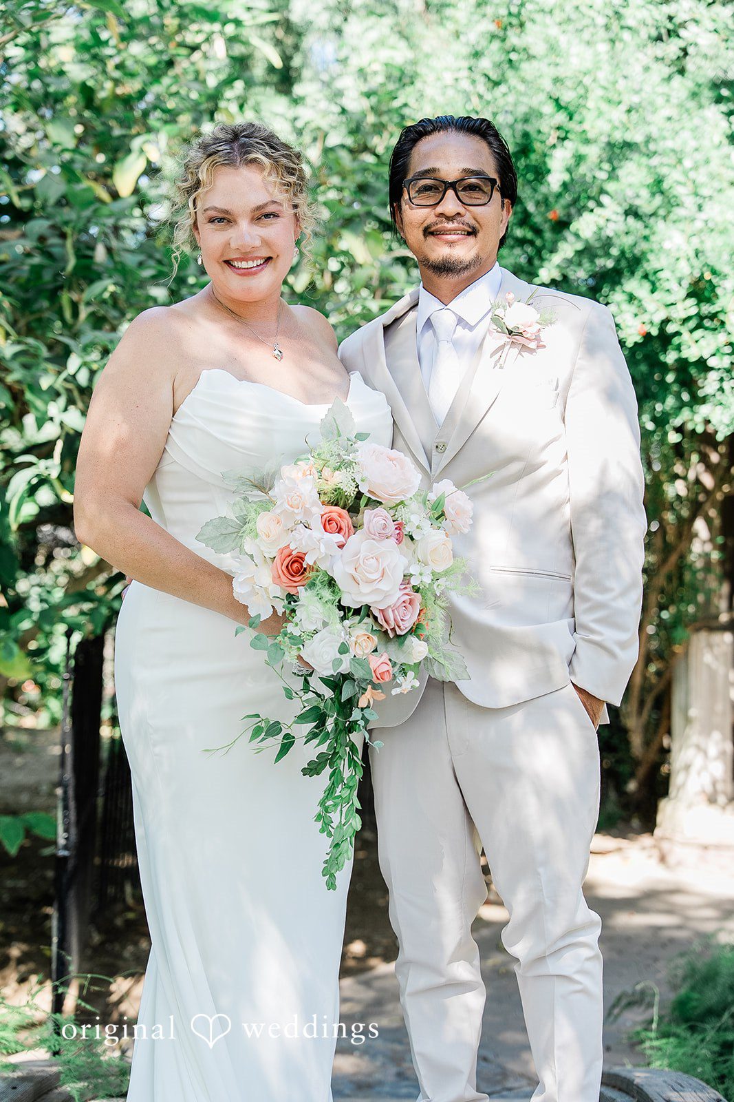 Lindsay + Ryan A bride holding a bouquet while standing next to a smiling groom in a white suit.