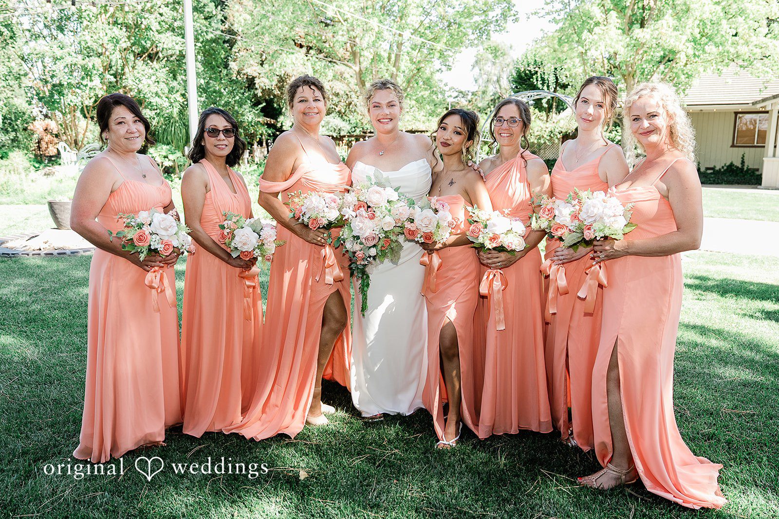 Lindsay + Ryan A bridal party wearing long peach gowns standing together for a group portrait.