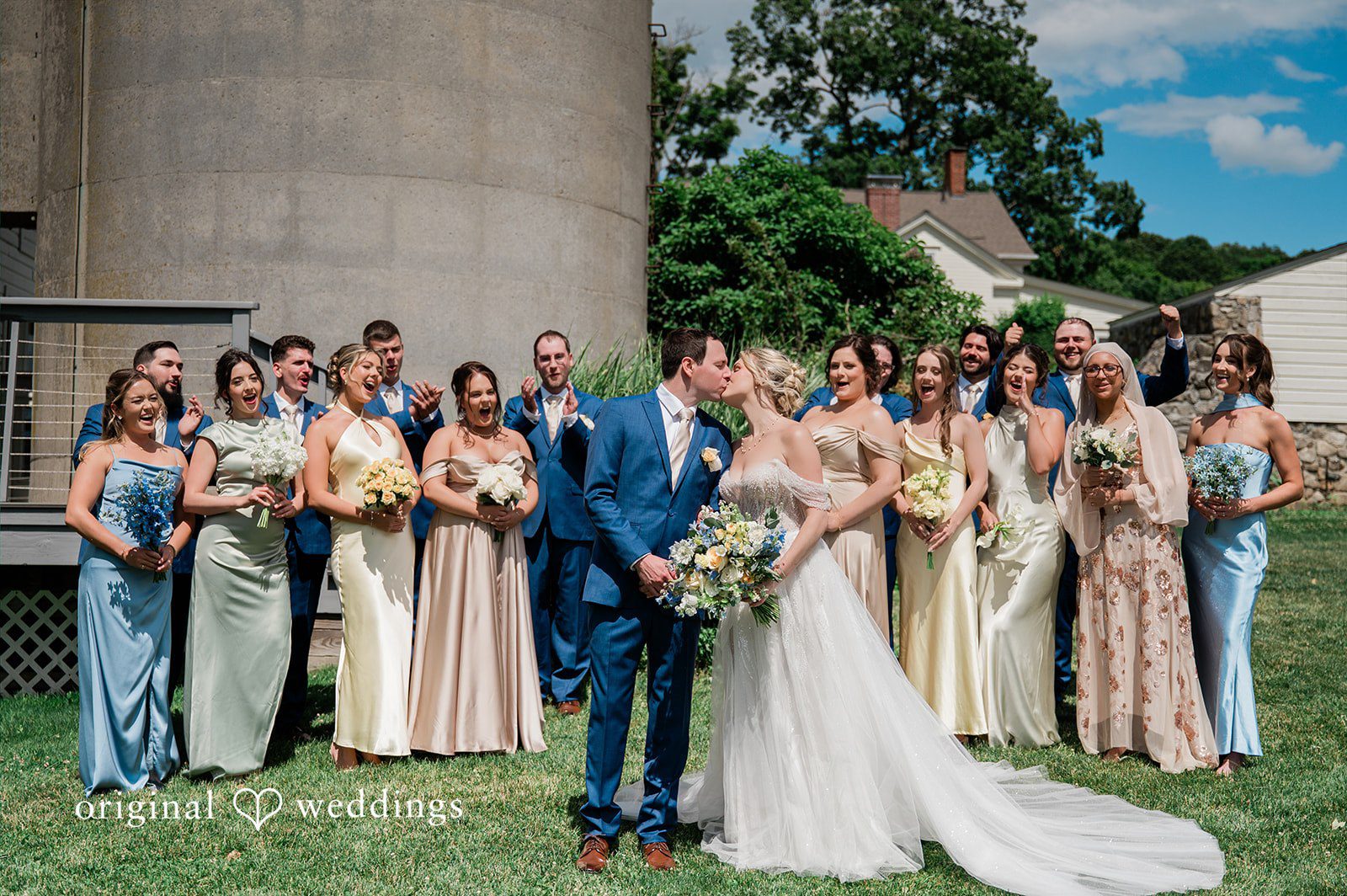 The couple shares a romantic kiss with cheers from their bridal party