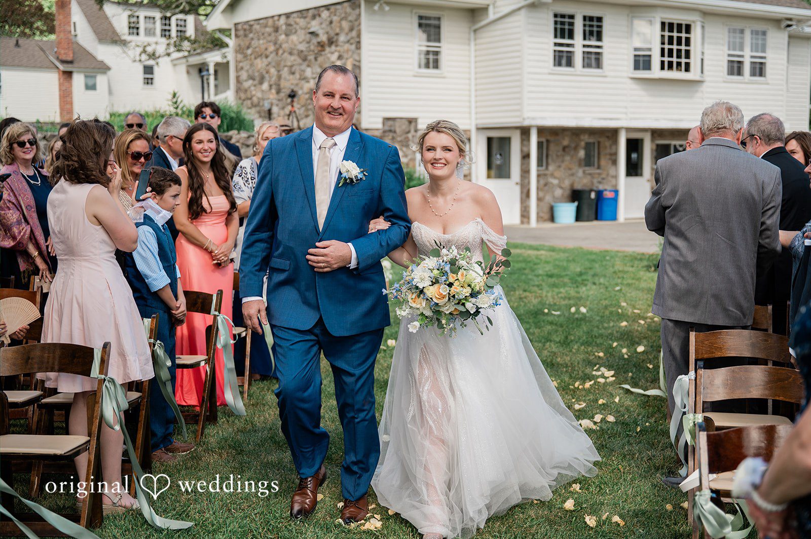 The bride's father escorts the bride down the aisle