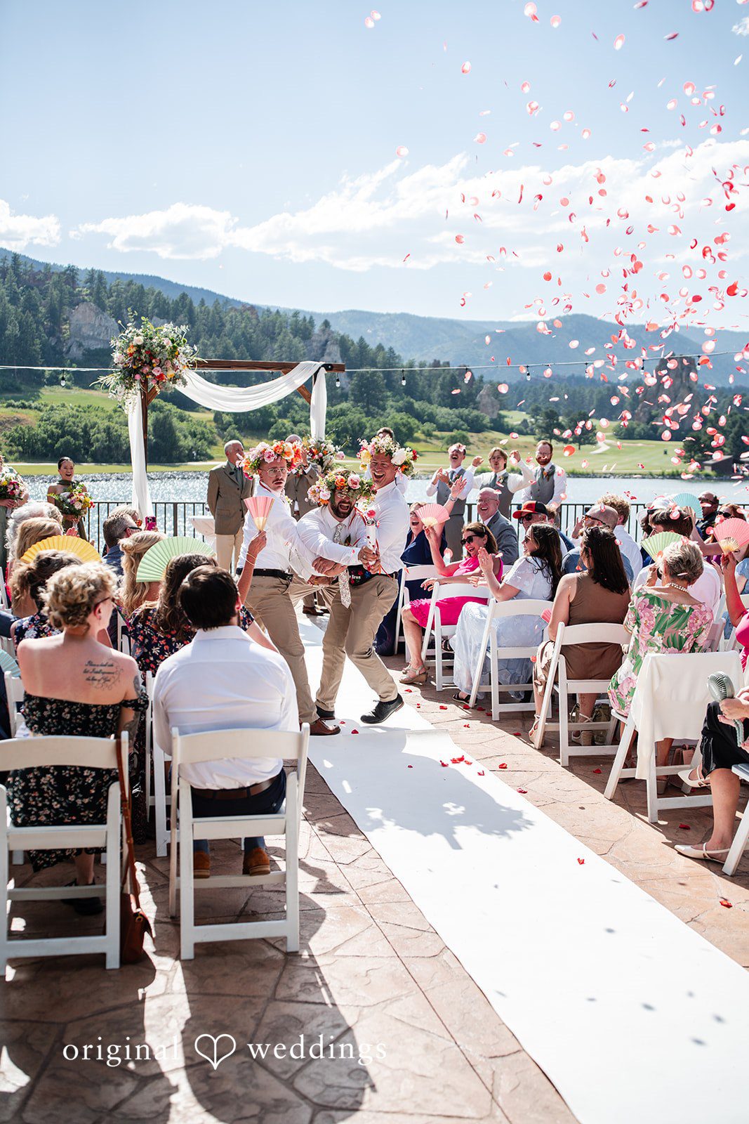 Mckenna + Ryan Guests seated in chairs during a ceremony near a body of water.