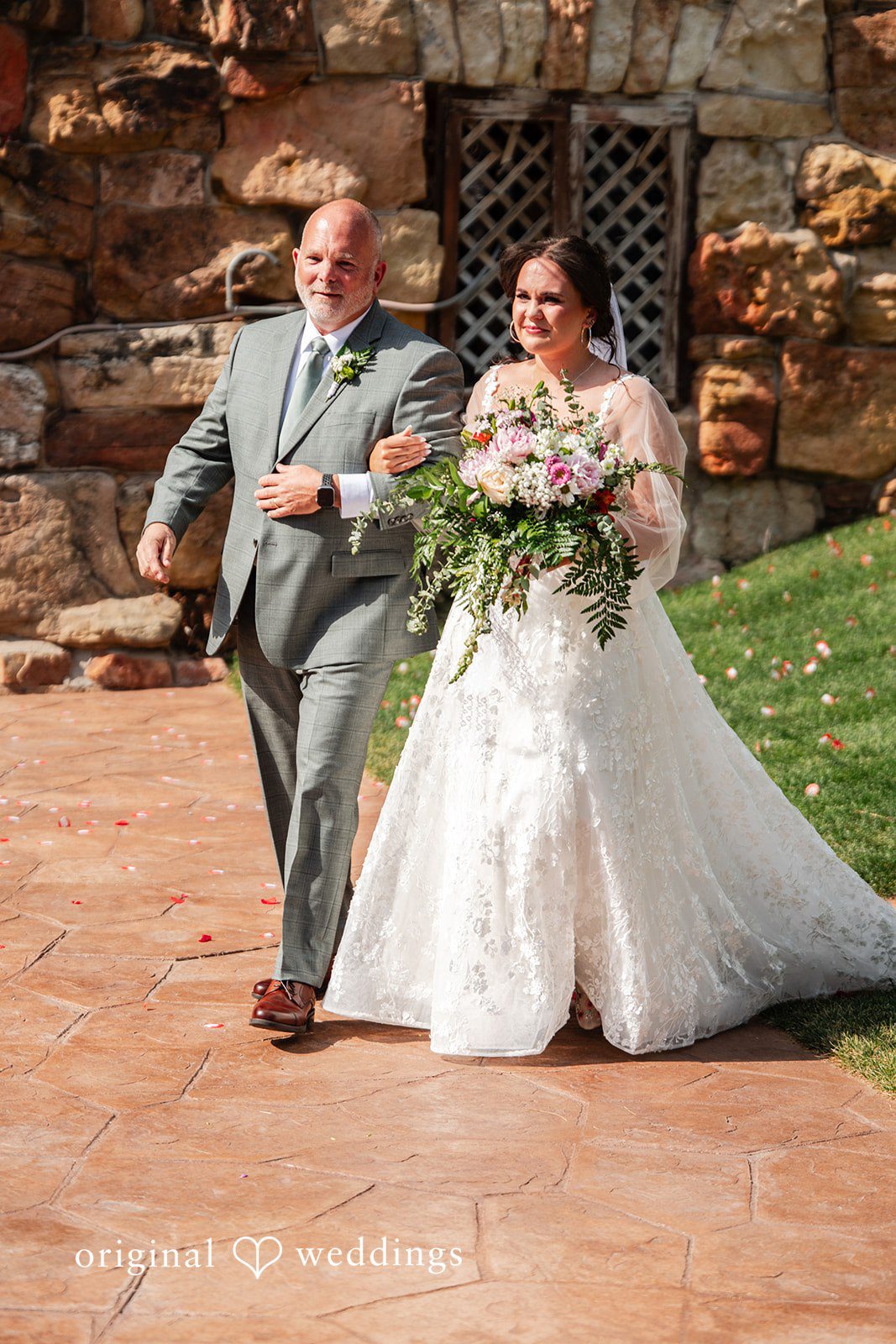 Mckenna + Ryan A bride and man walking hand-in-hand down stone steps.