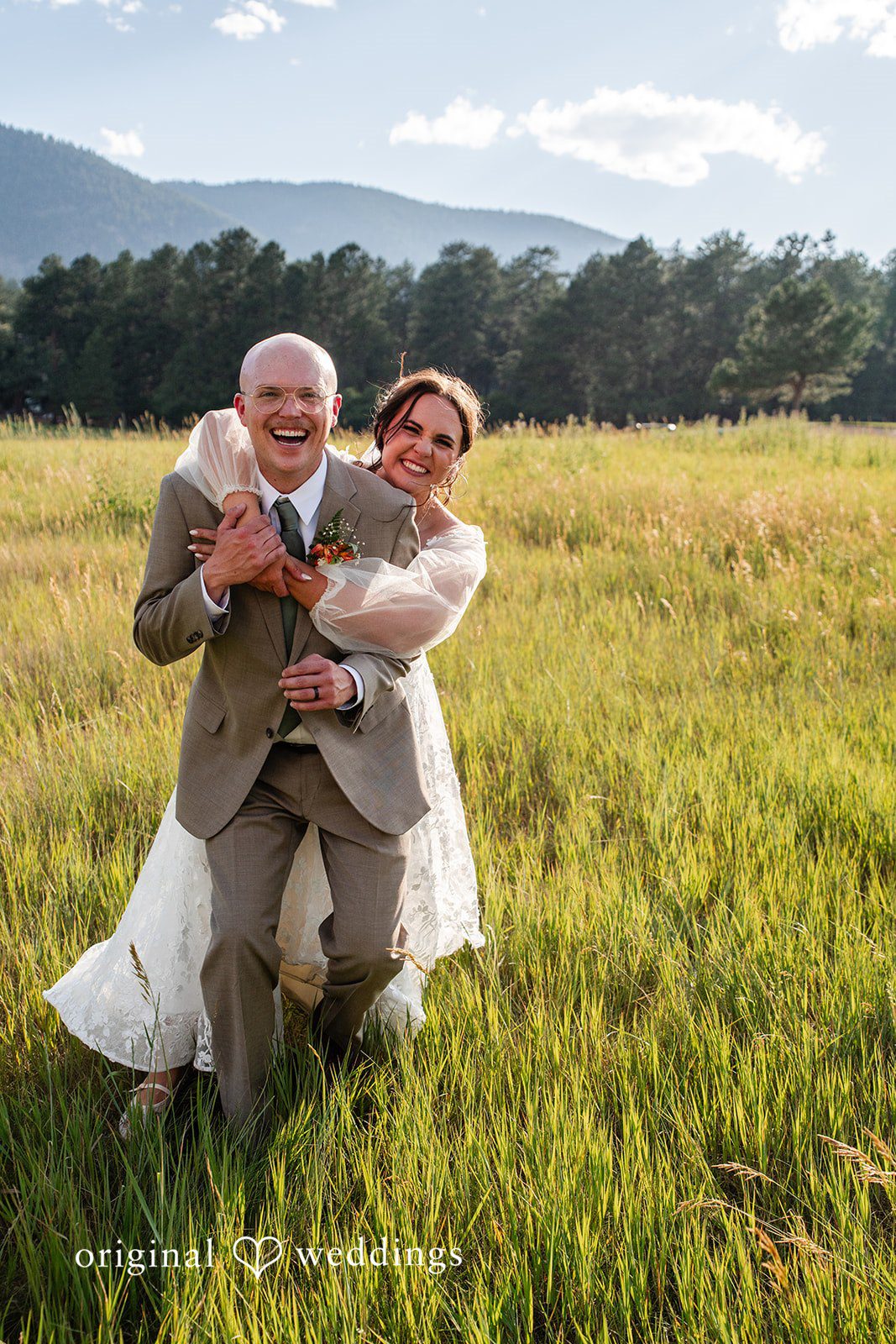 Mckenna + Ryan A groom playfully carrying his bride on his back through a grassy field.