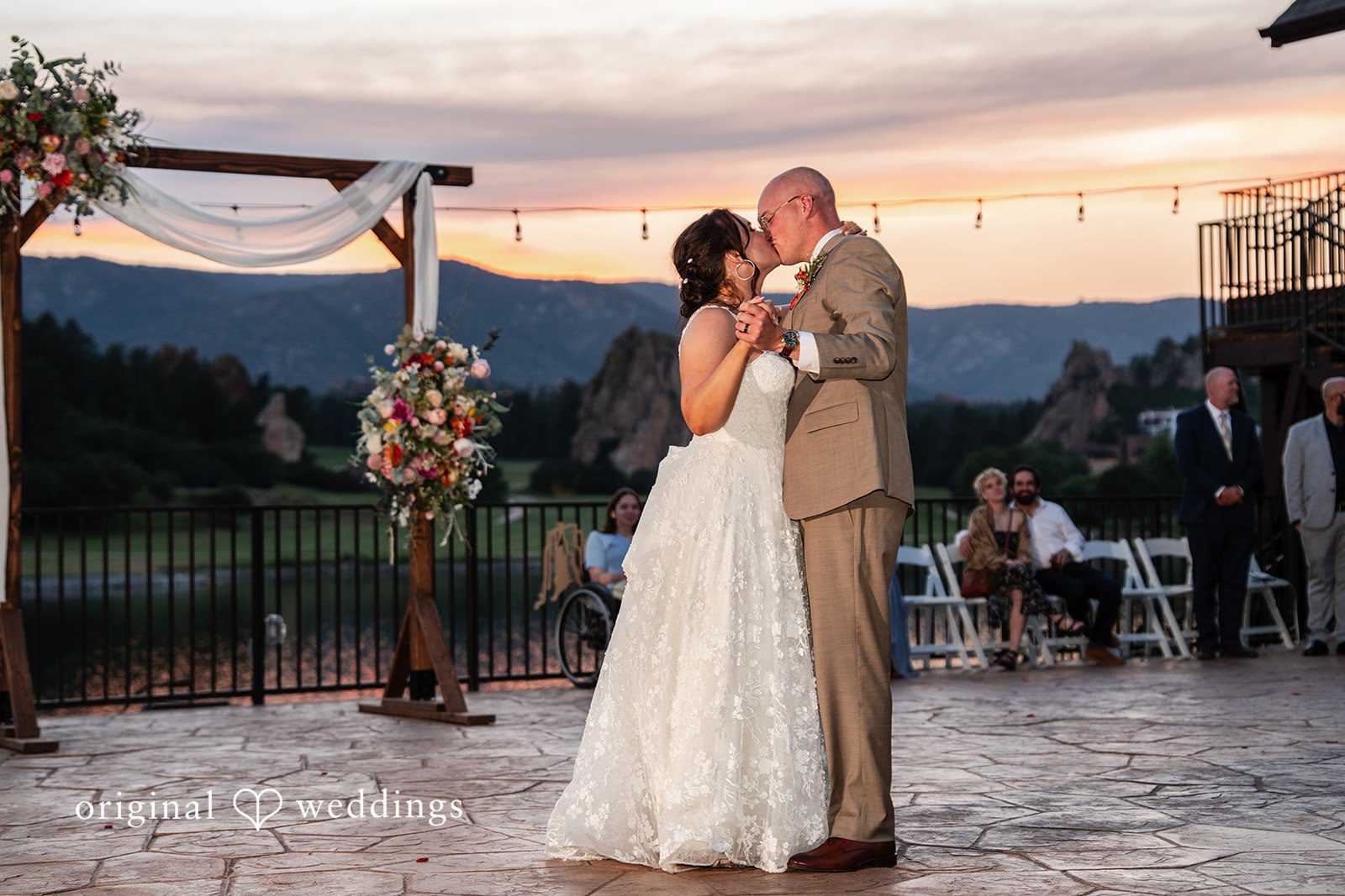 Mckenna + Ryan A bride and groom sharing a dance on an illuminated floor during dusk.