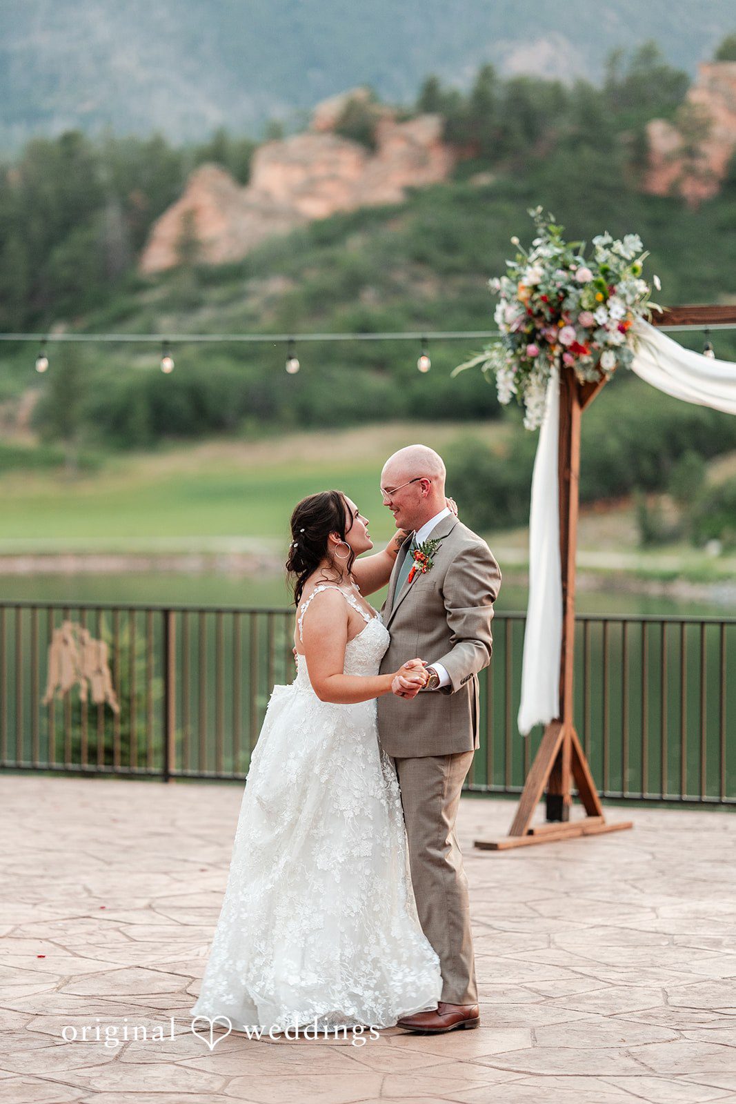 Mckenna + Ryan A bride and groom facing each other at a ceremony on a stone patio.