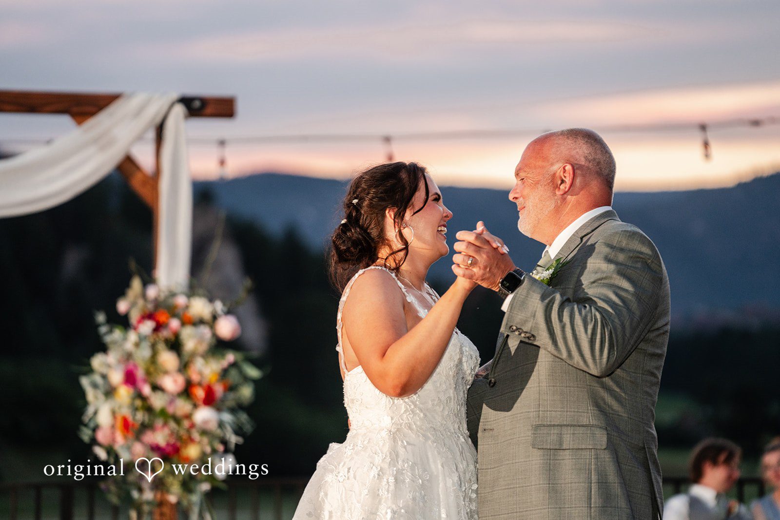 Mckenna + Ryan A bride dancing with man under a decorated wooden canopy.