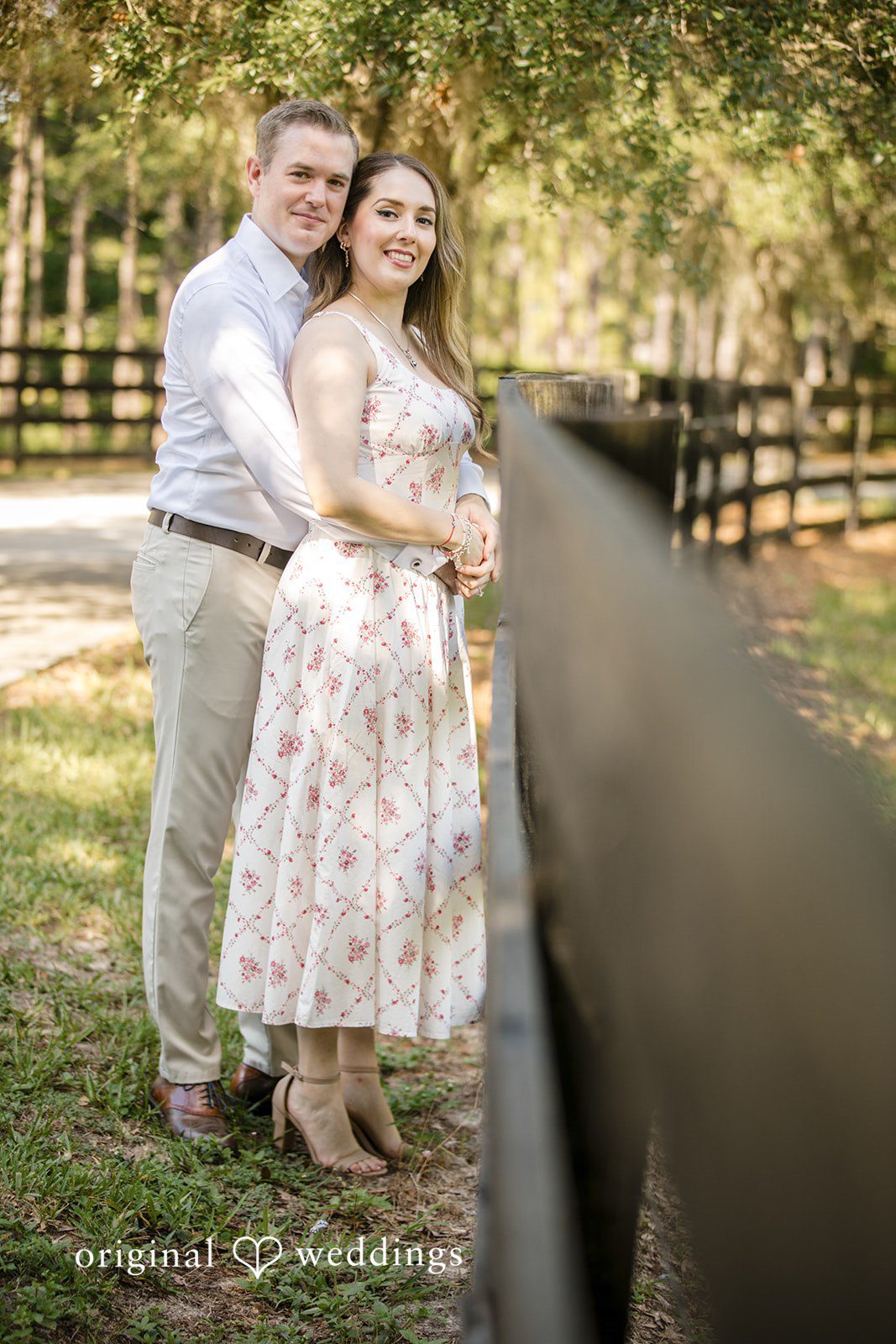 Woman leaning back against a railing while a man stands beside her.