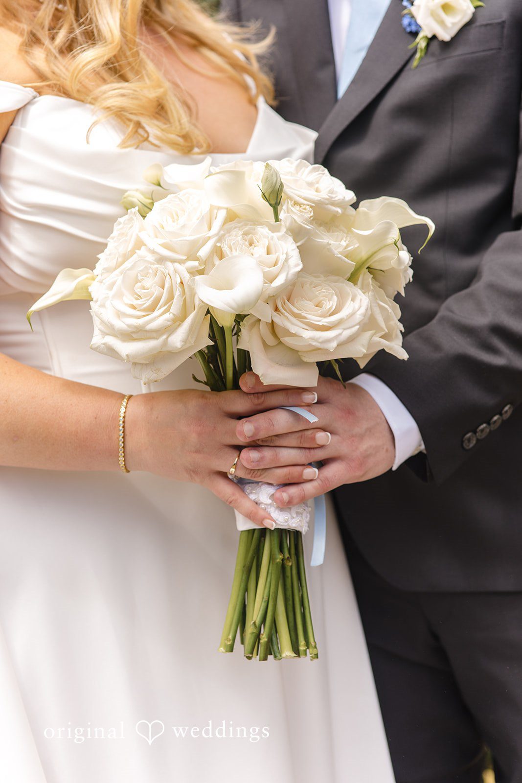 Madelyn + Connor A close-up of a bride holding a white bouquet while standing next to her groom.