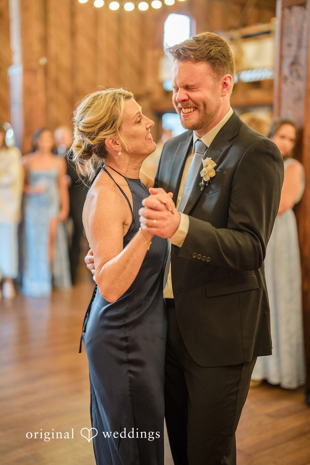 Madelyn + Connor A man in a dark suit dancing with a woman in a navy dress during a reception.