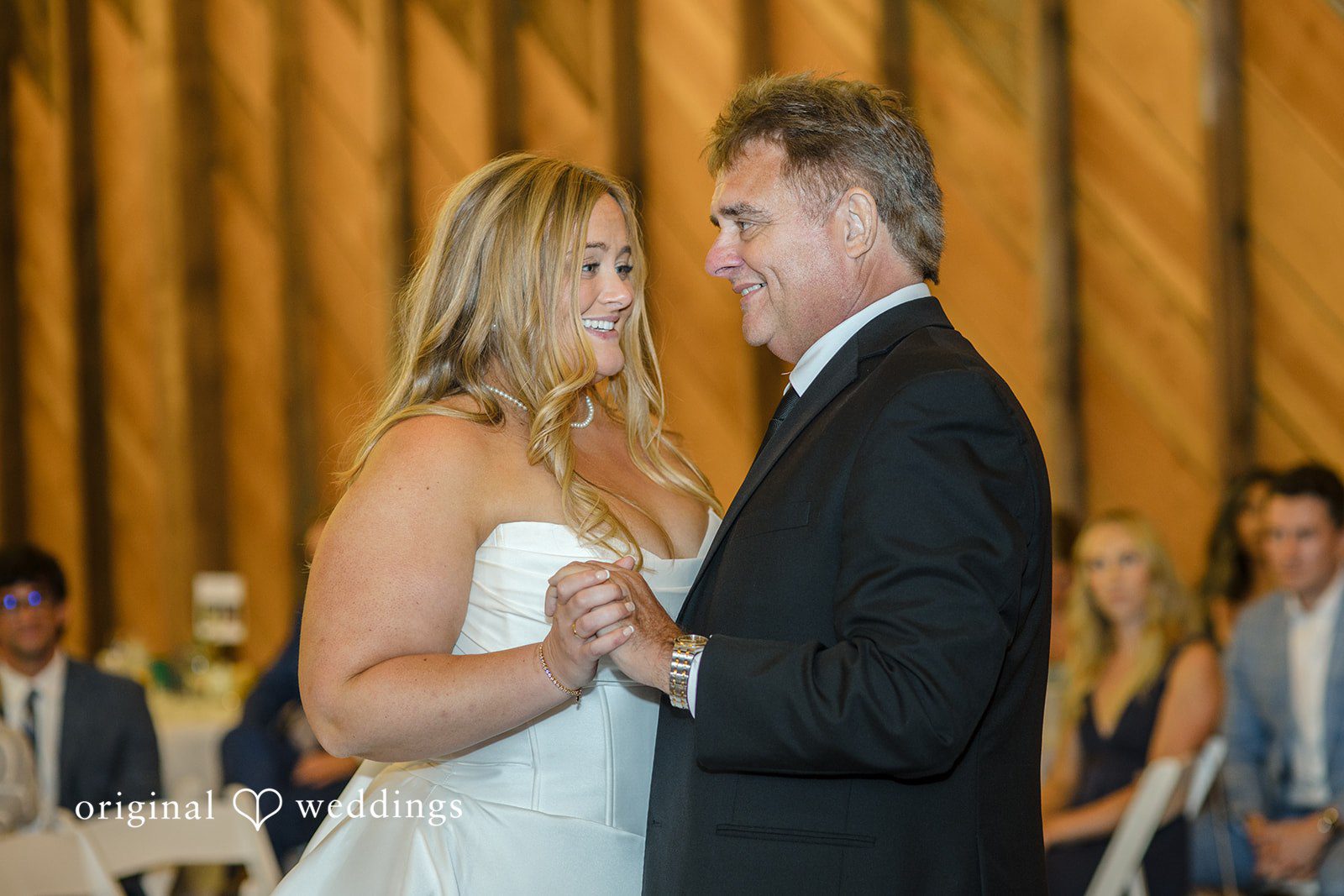 Madelyn + Connor A bride dancing with a man in a dark suit while looking at each other.