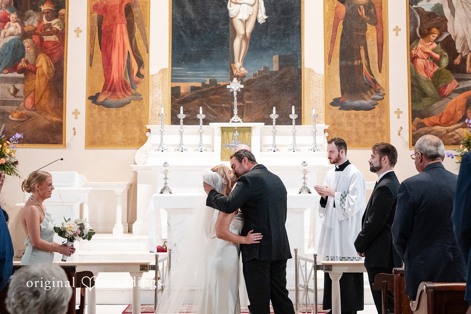 Maggie + Taylor A bride and groom share a kiss at the altar after being married.