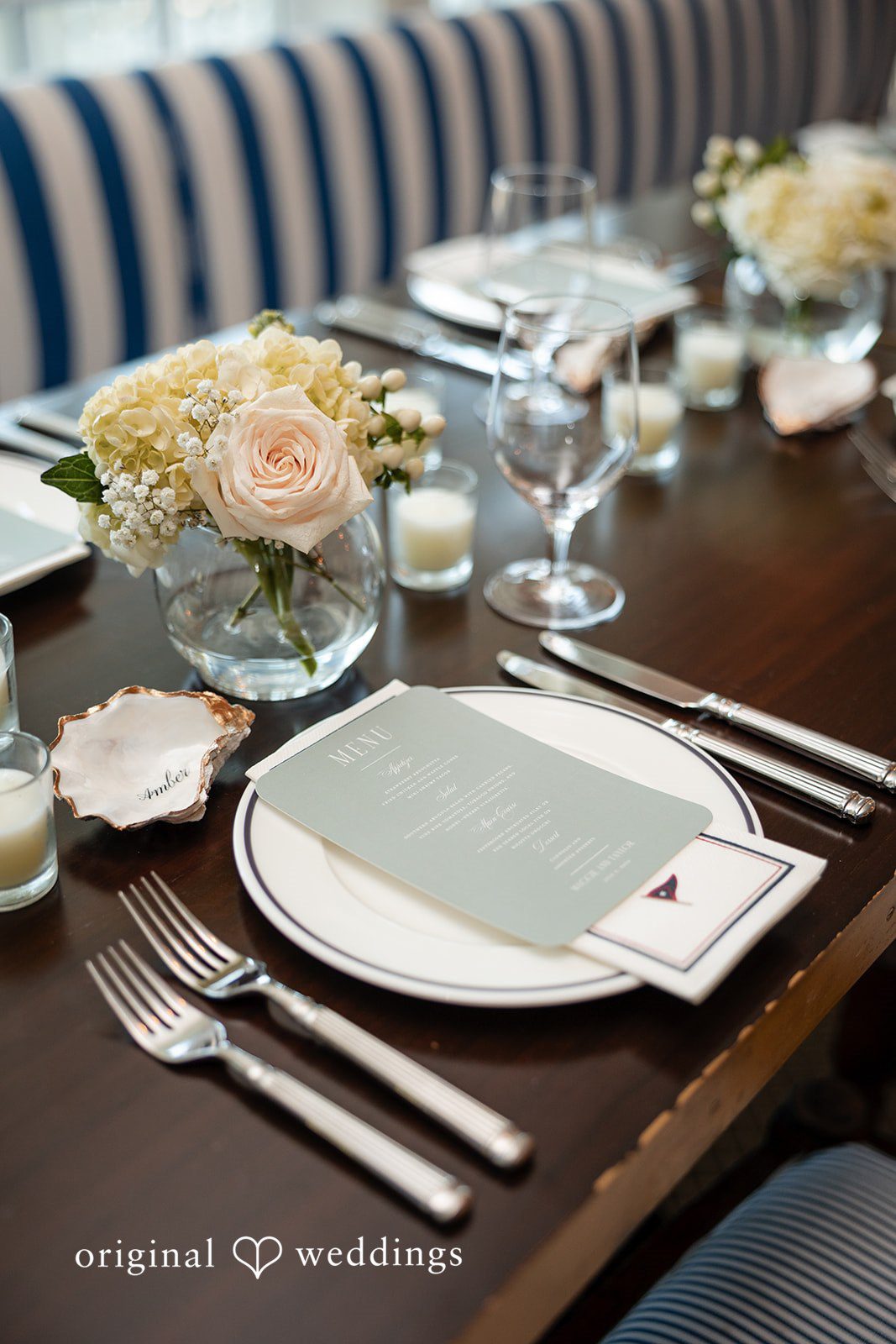 Maggie + Taylor A close-up view of an elegant wedding table setting with white plates and glassware.