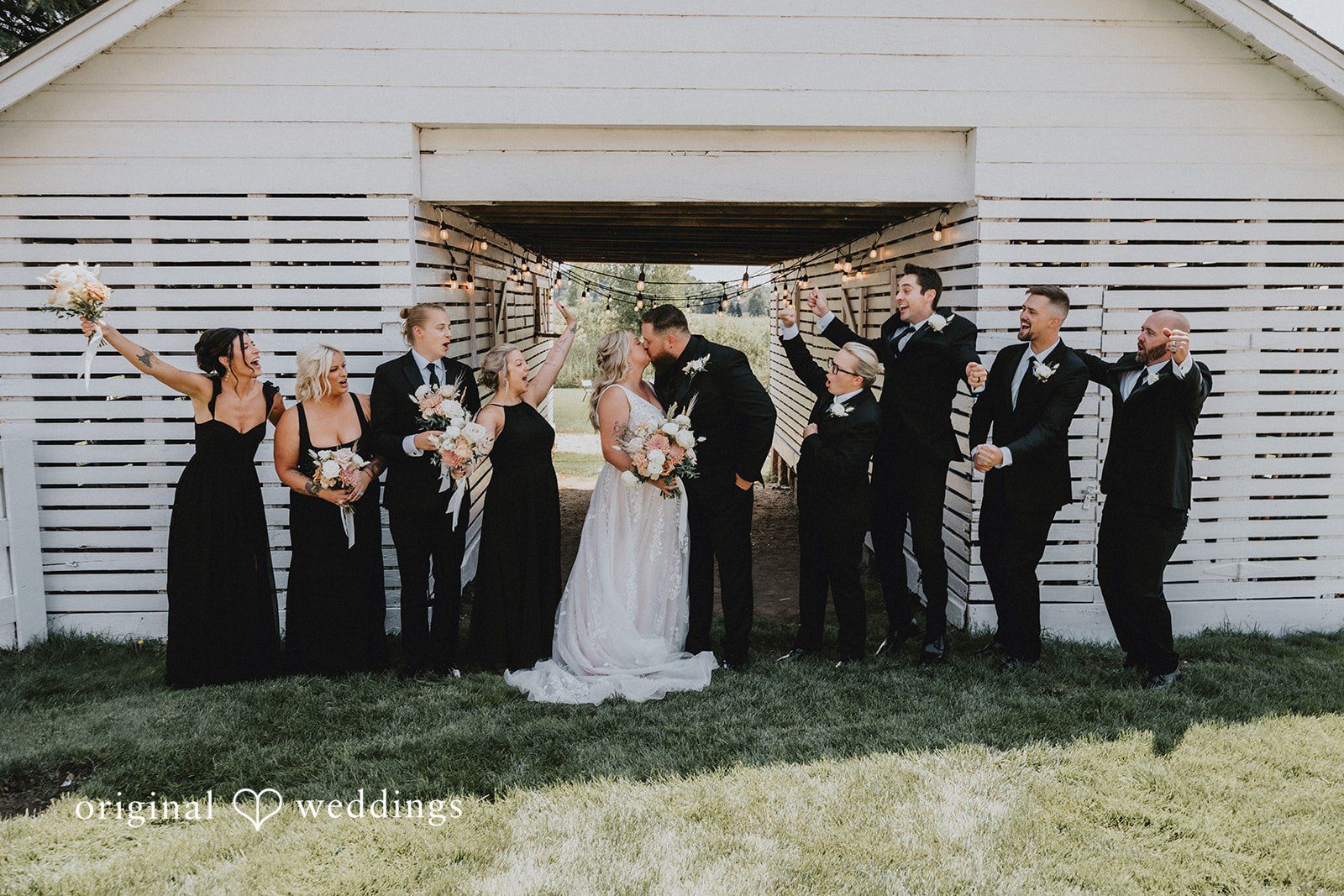 Samantha + Peyton Bridesmaids and groomsmen lined up outside a rustic wooden pavilion.