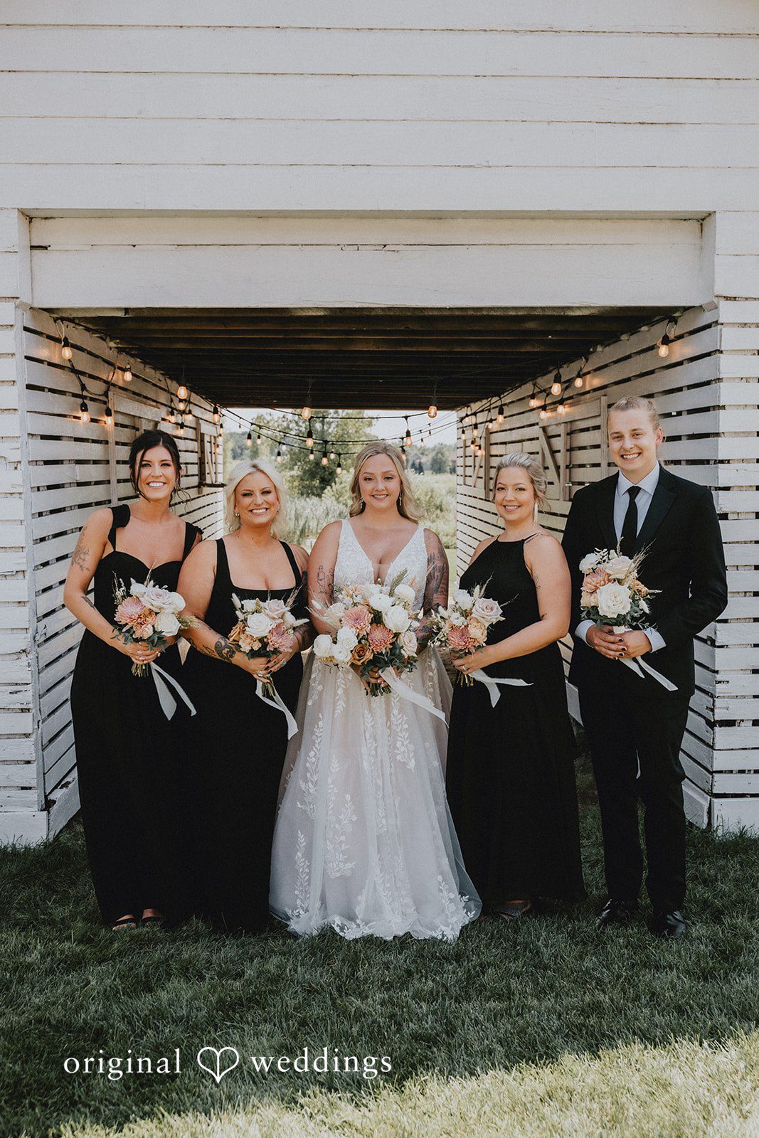 Samantha + Peyton Wedding party posing together against a rustic wooden wall.