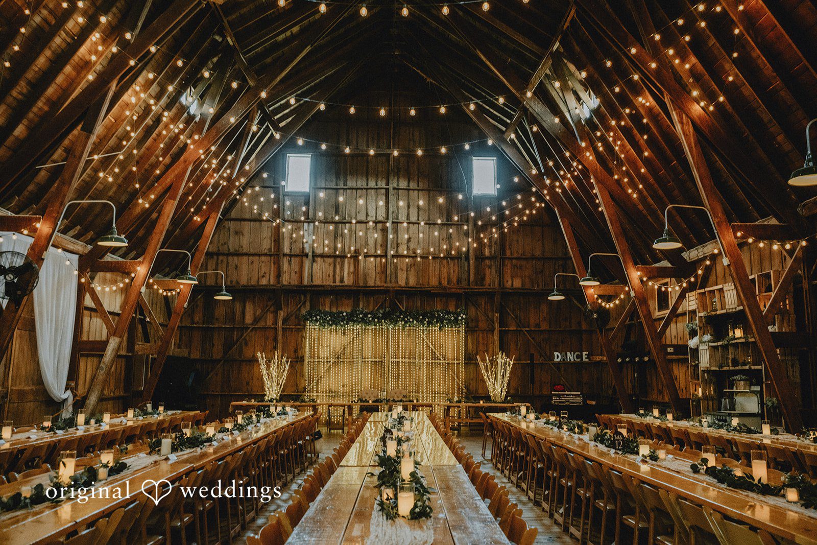Samantha + Peyton Banquet hall decorated with long tables and string lights.