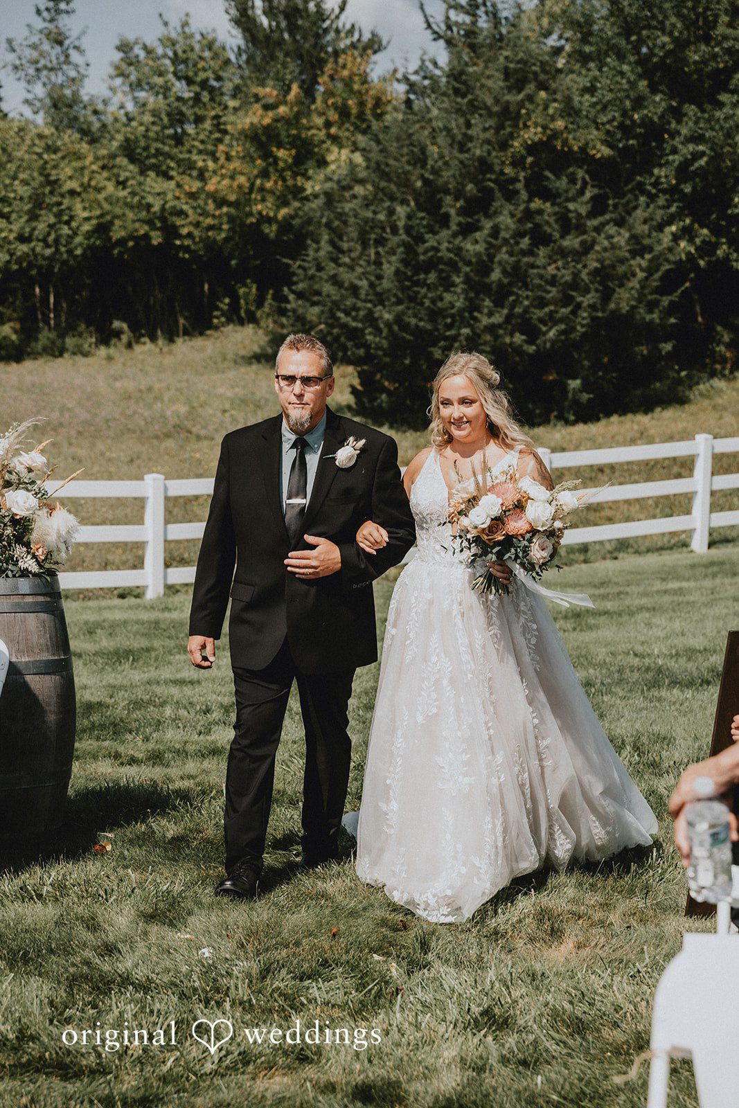 Samantha + Peyton Newlyweds walking together down a pathway next to a fence.