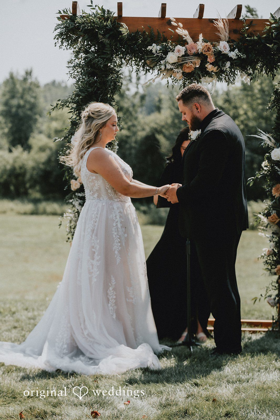 Samantha + Peyton Newlyweds holding hands during their wedding ceremony.