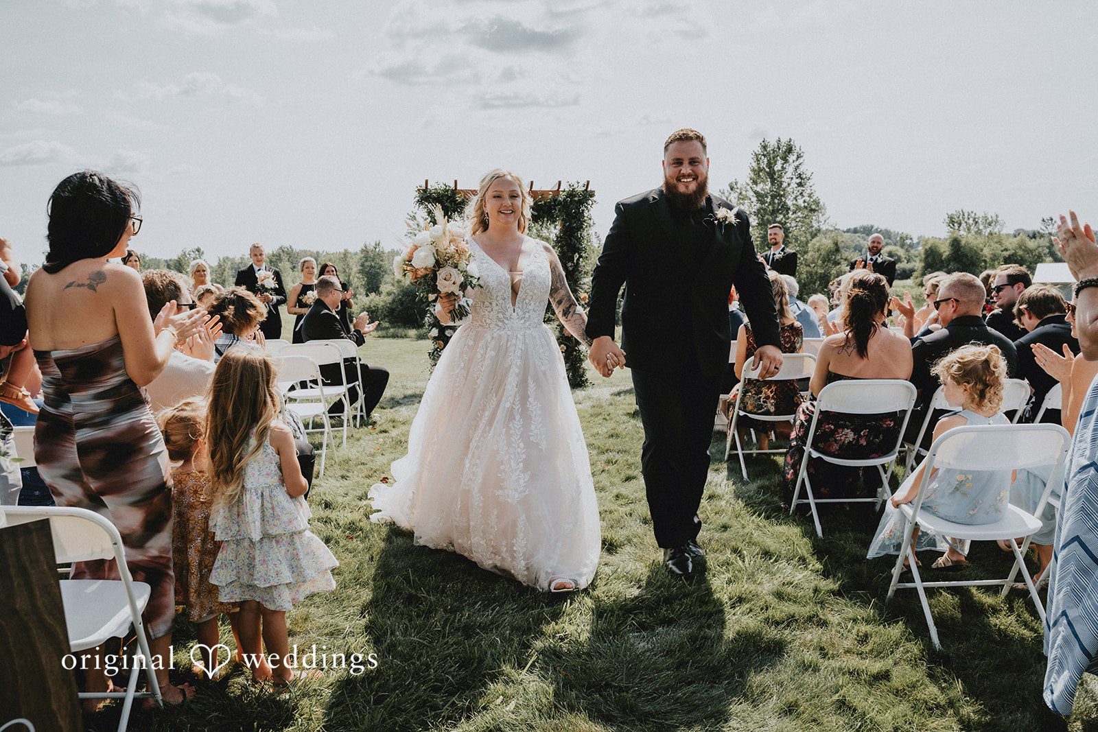 Samantha + Peyton Newlyweds walking away hand in hand down the aisle.