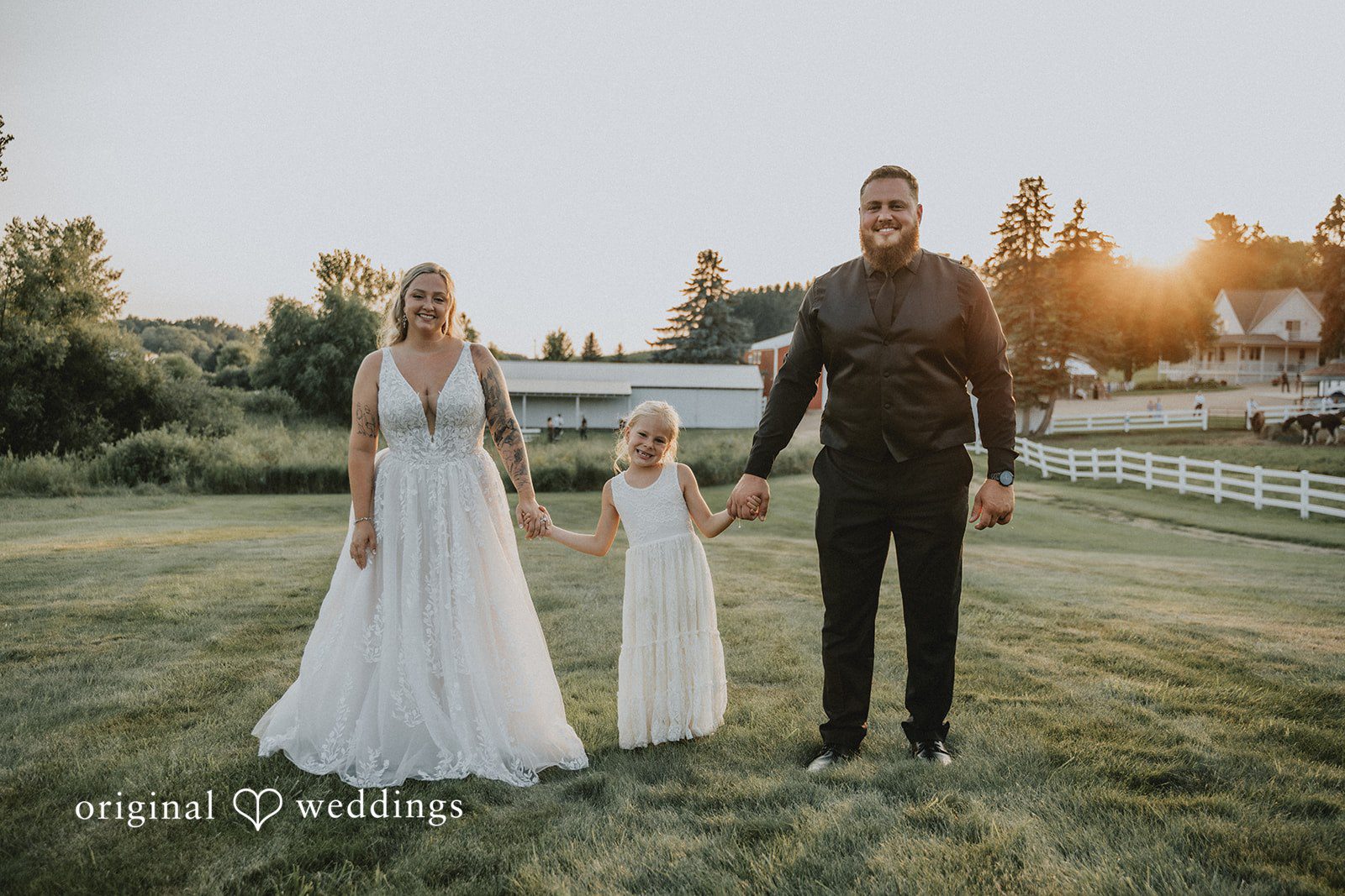 Samantha + Peyton Bride and groom walking hand in hand with a young flower girl.