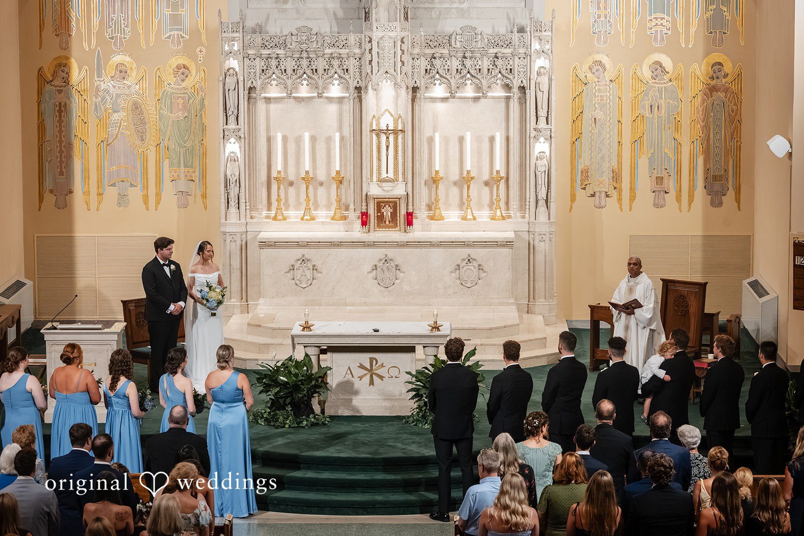 Mark + Caroline A high-angle view of a wedding ceremony taking place at the front of a church sanctuary.