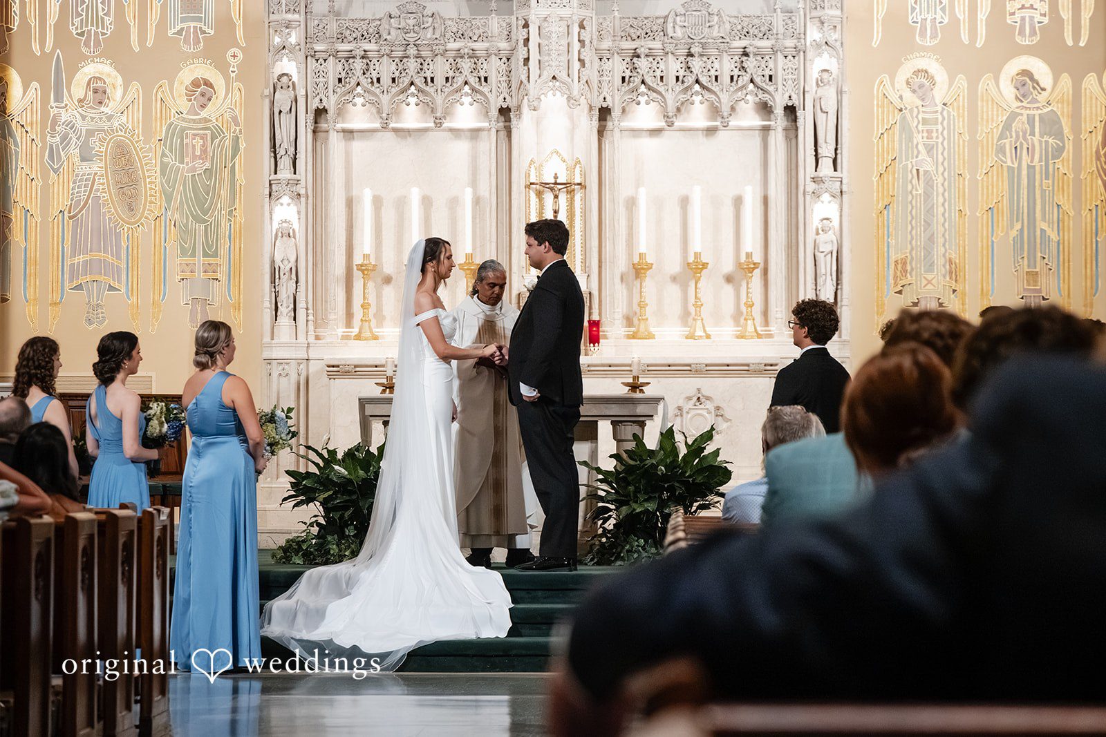 Mark + Caroline The bride and groom exchanging vows at the altar in front of their guests.