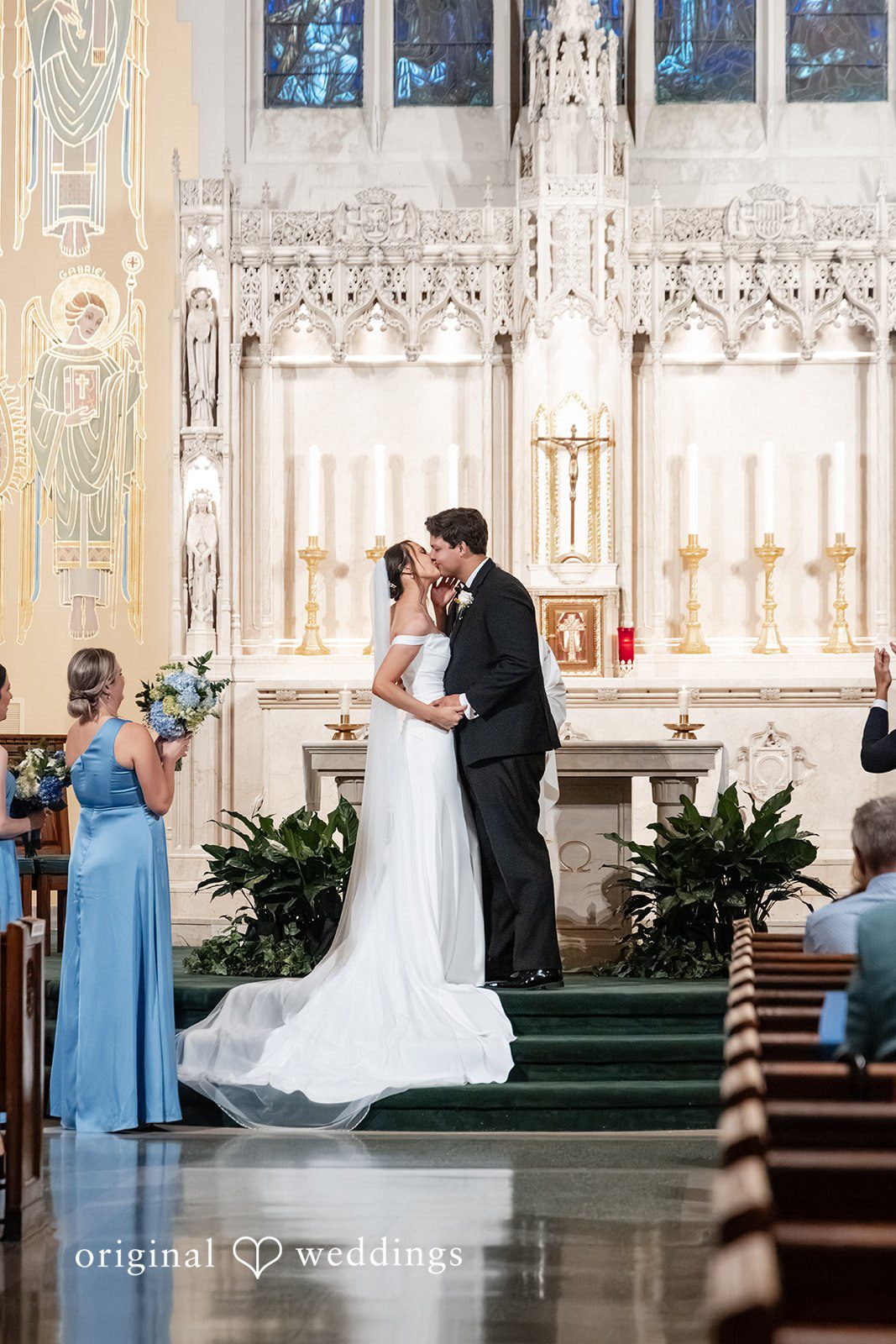 Mark + Caroline The bride and groom sharing a kiss at the altar during their wedding ceremony.