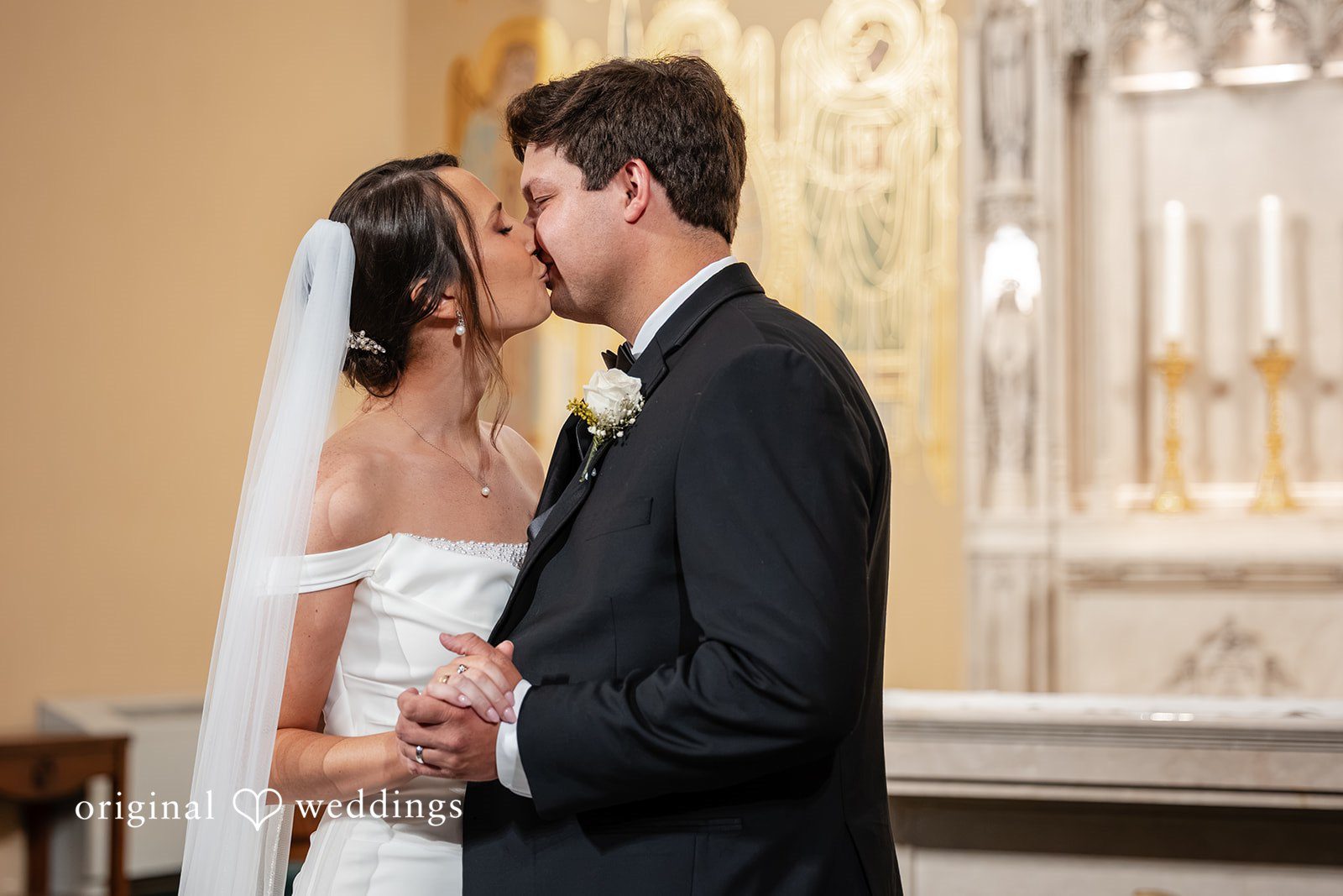 Mark + Caroline A close-up profile view of the bride and groom sharing a kiss during the ceremony.