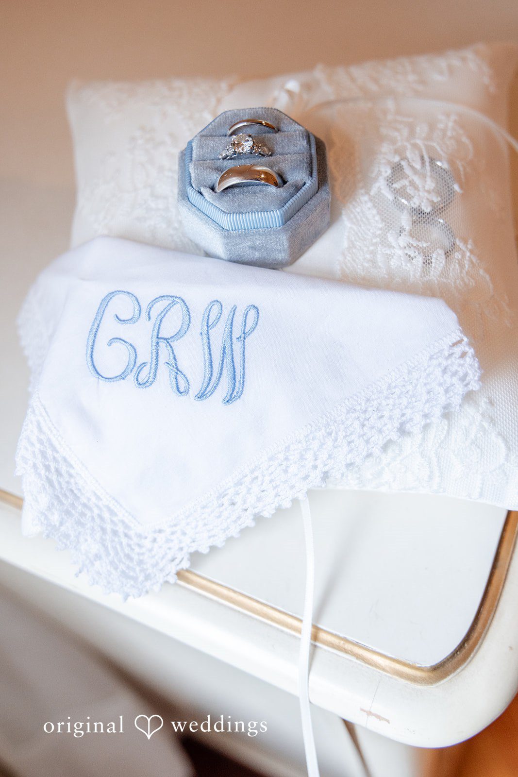 Mark + Caroline A close-up of a white wedding pillow embroidered with the initials "GRW."