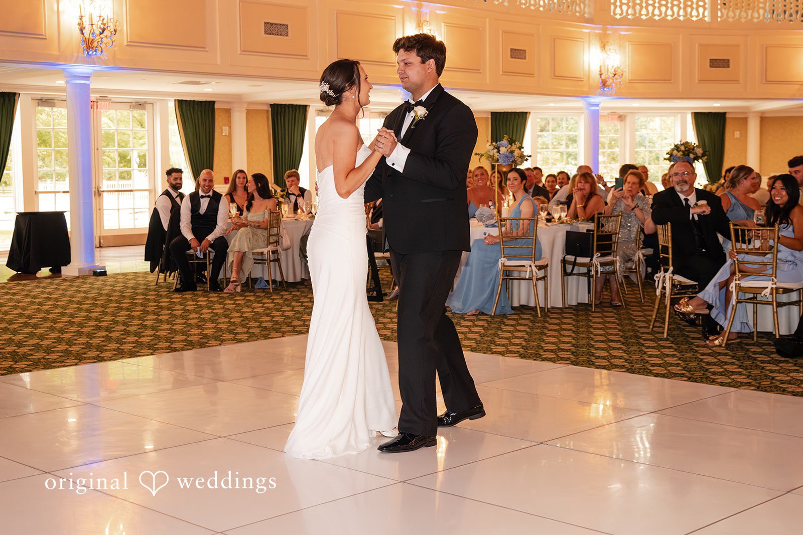 Mark + Caroline The bride and groom sharing their first dance in the center of a reception ballroom.