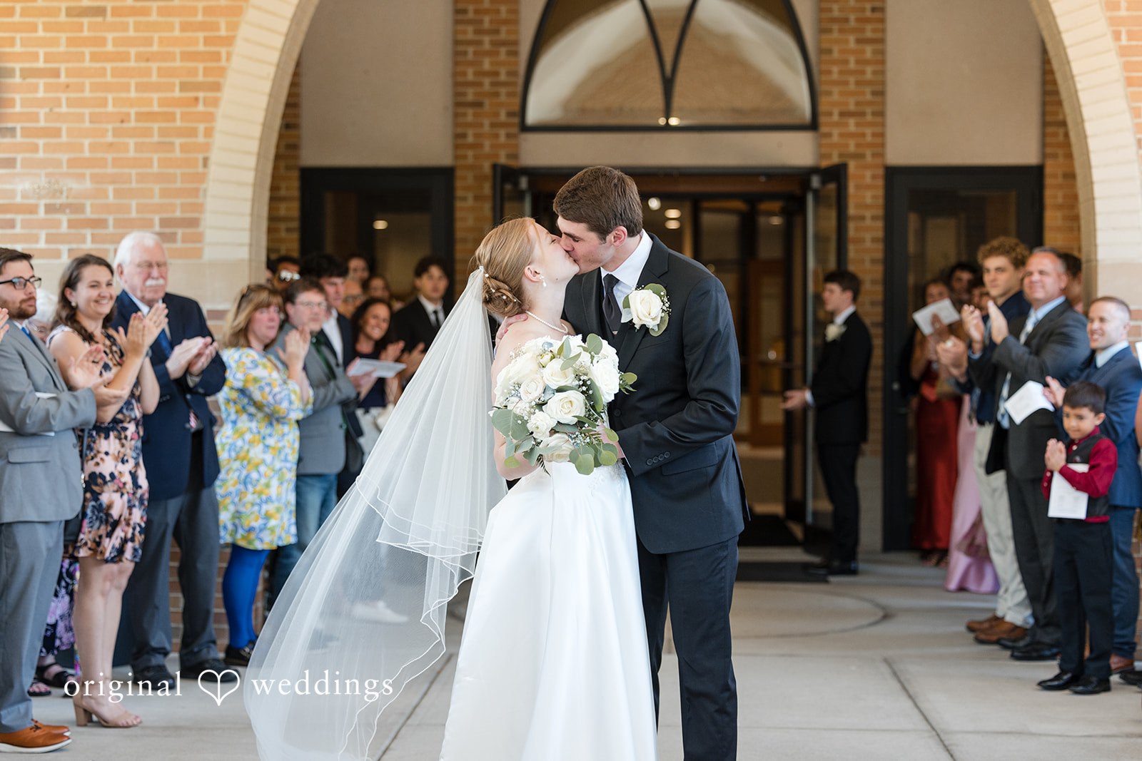 Cora + Michael Elegant bride and groom kissing outside at the Emerald Event Center