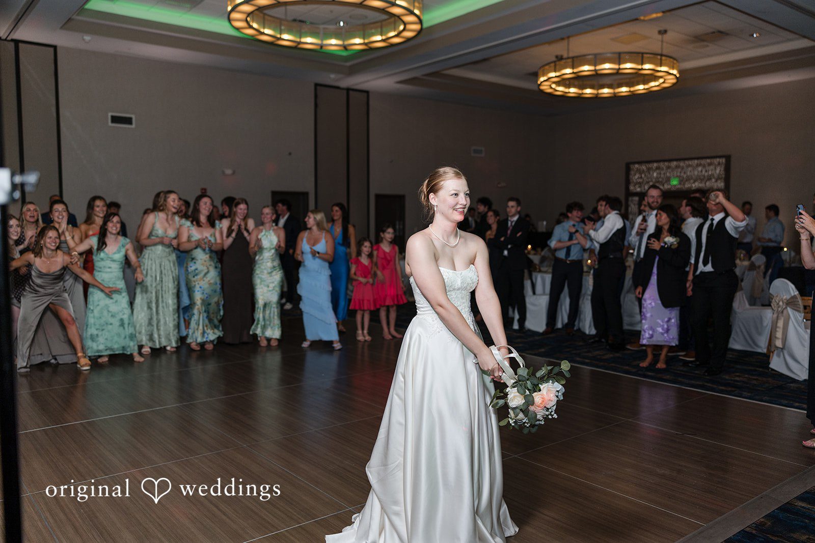 Cora + Michael Romantic bride bouquet toss moment at the Emerald Event Center