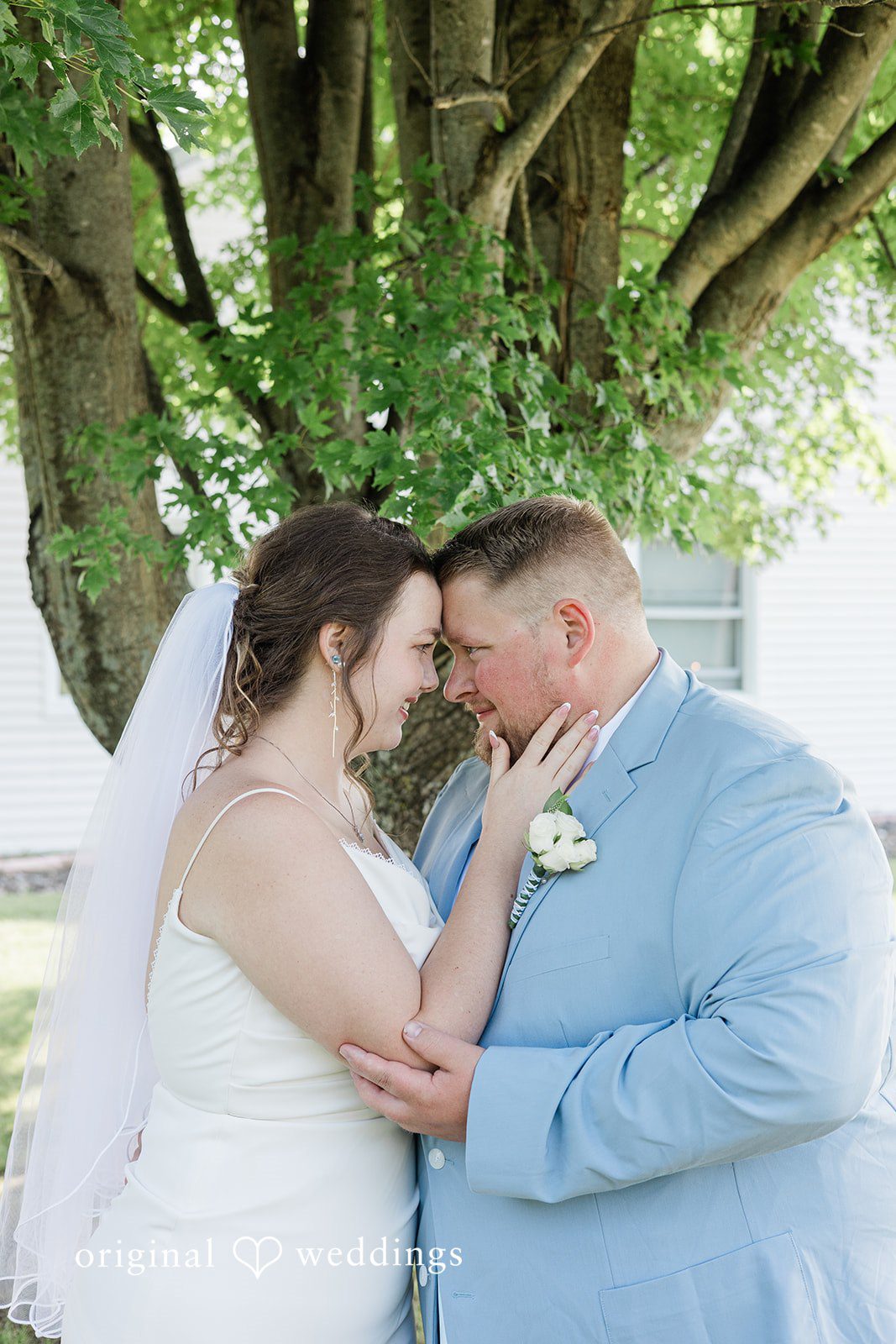 Michaela + Jake A bride and groom share an intimate moment leaning their foreheads together.