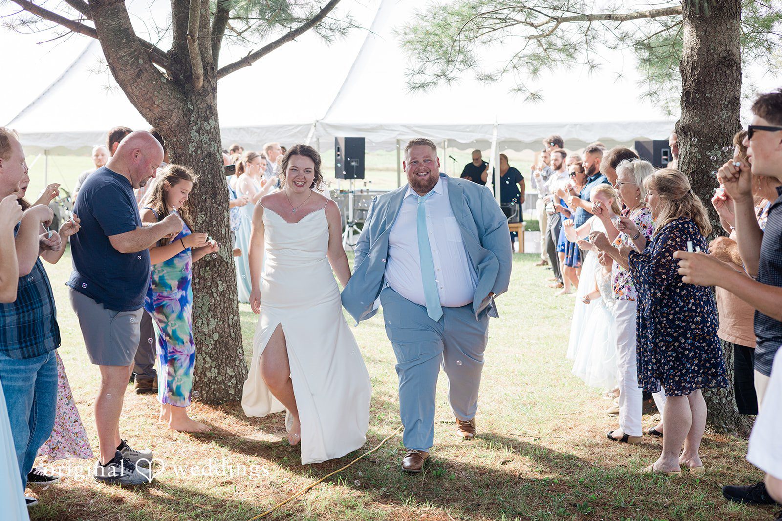 Michaela + Jake Guests watch a bride and groom walk down an aisle after the ceremony.