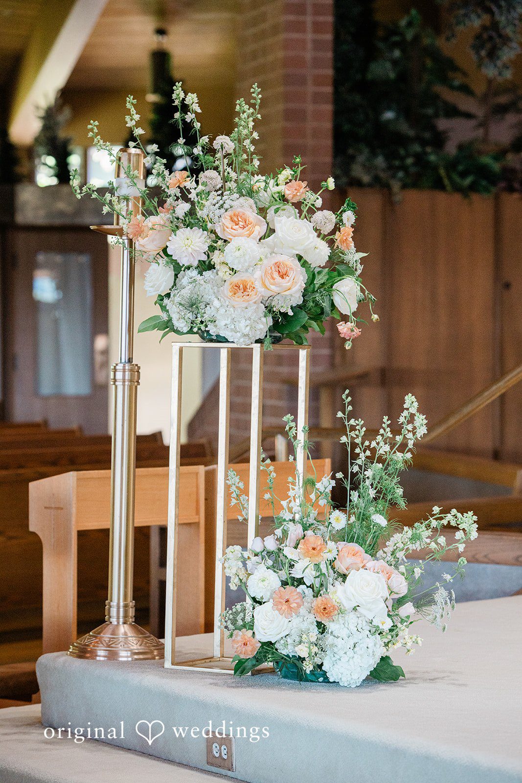 Vibrant floral arrangement displayed on a tall gold geometric stand.